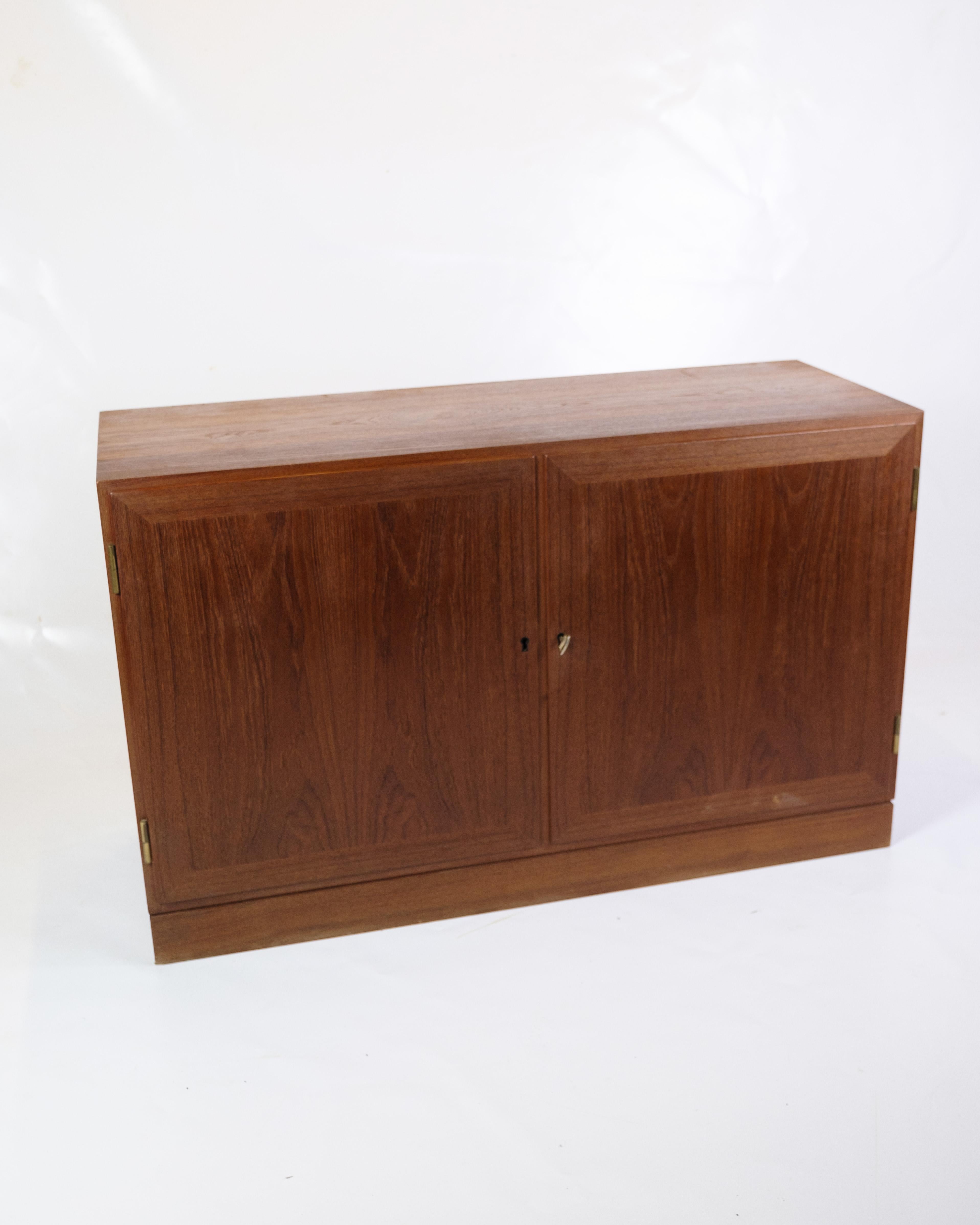 Made of teak and dating from the 1960s, this small sideboard is a beautiful example of period furniture from this era. With its compact design and use of teak wood, the sideboard exudes a timeless elegance and simplicity that is characteristic of