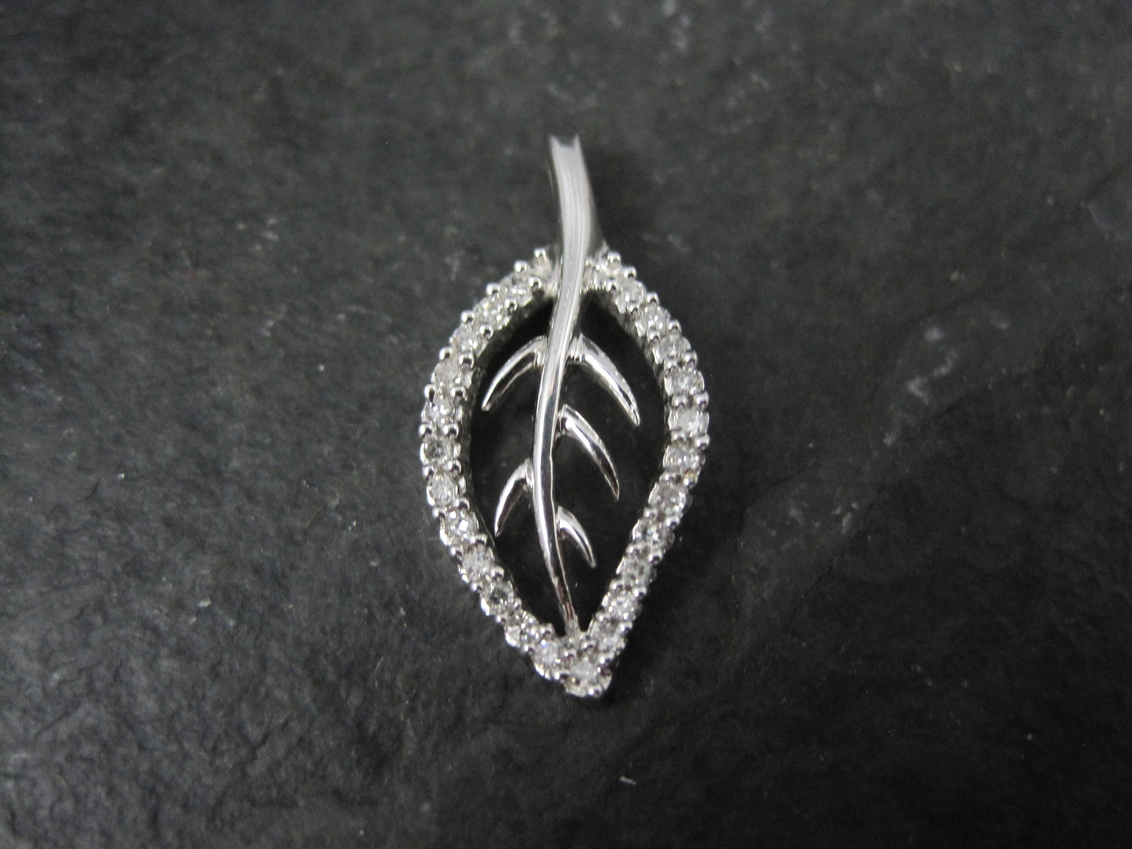 This beautiful leaf pendant is 10k white gold.
It features an estimated .20 carats in round diamonds.

Measurements: 7/16 by 15/16 of an inch

Marks: 10K, SUN
This hallmark belongs to the Diamond Sun Corp

Condition: Excellent