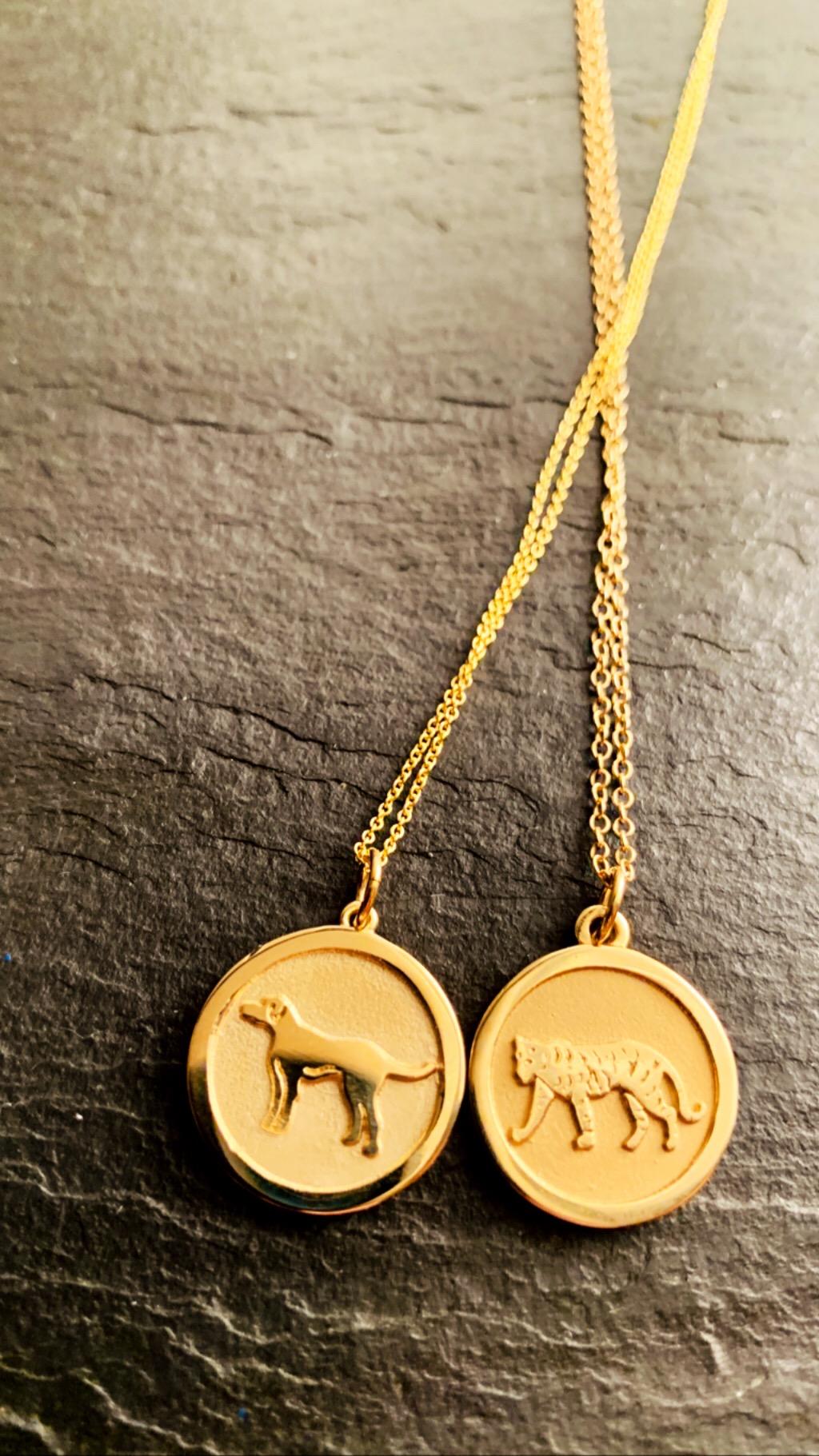 La nostra collezione Zodiac cinese. Ognuno dei dodici Animali dello Zodiaco, sia che si muova in avanti o che stia in piedi, è stato progettato per impartire forza e resilienza.

Questo medaglione a forma di cane è scolpito a mano nella cera e fuso