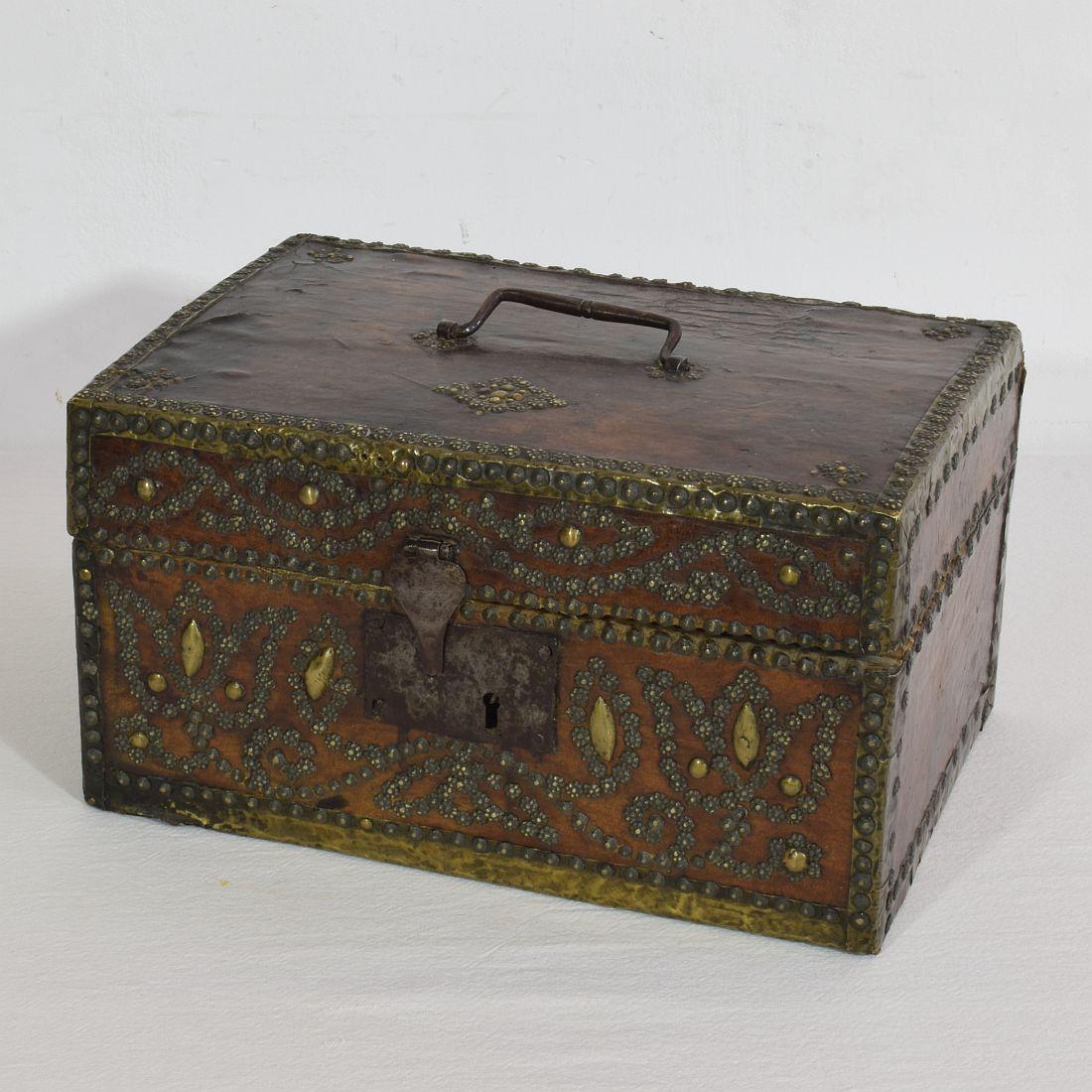 Extremely old box that is covered with leather and decorated with iron and brass. 
Rare find.
France, circa 1600-1700
Weathered and some losses.