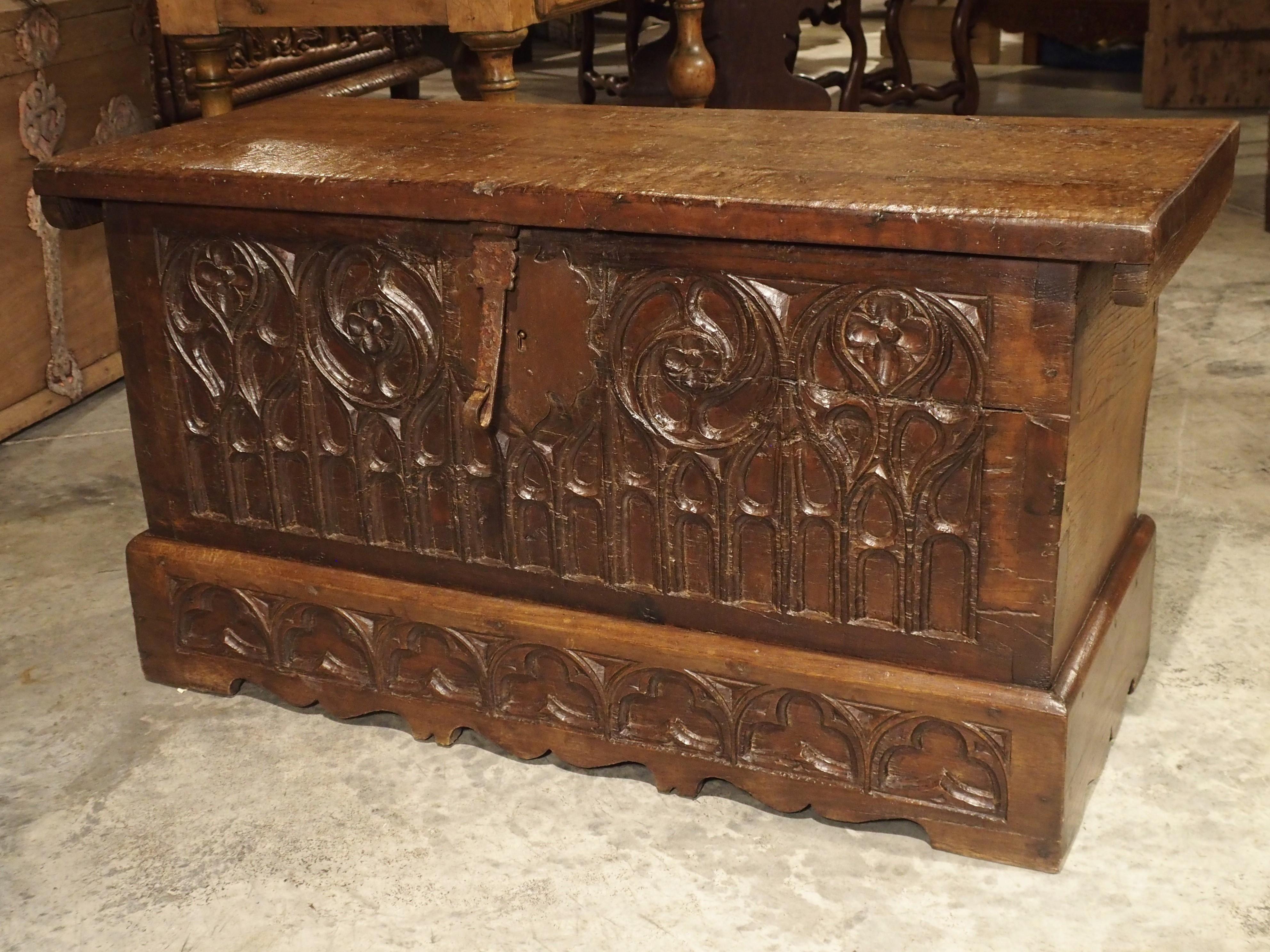 This 17th century French, hand carved oak trunk has wonderful French waxed patina. It has a frontage carved in the Gothic style of ornamentation. The facade is composed of 4 upper circular forms which transition into an arcade spanning the entire