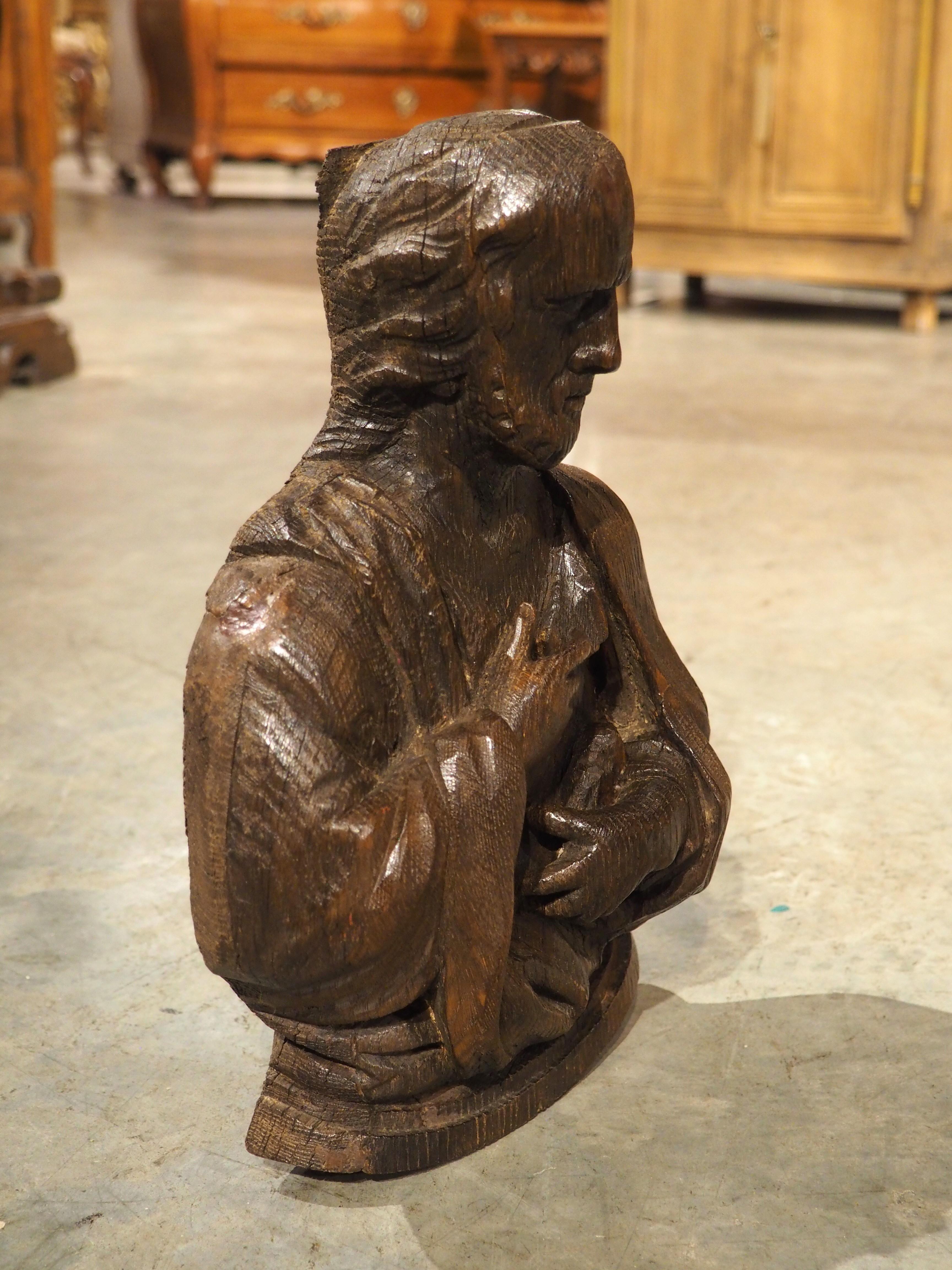 Un piccolo busto di Oak, risalente al 1600, questa statua in legno ben scolpita proviene dalla Francia. Raffigurante una figura religiosa sconosciuta, la scultura presenta una patina marrone profonda e ricca, che esalta le sfumature degli intagli.