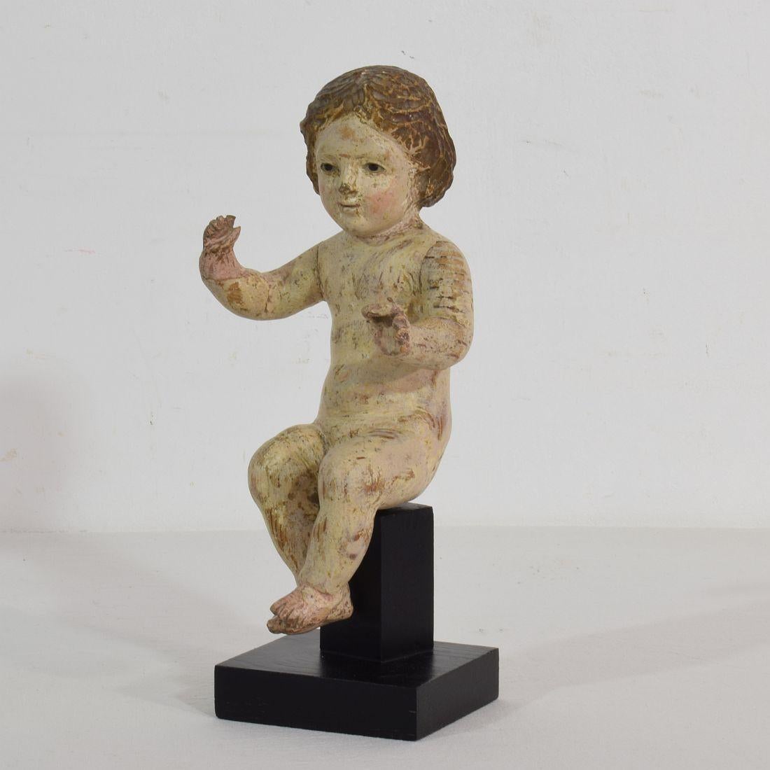 Beautiful small baby Jesus with glass eyes and its original color,
Spain, circa 1750. Weathered, small losses and old restorations. Measurement with the base.