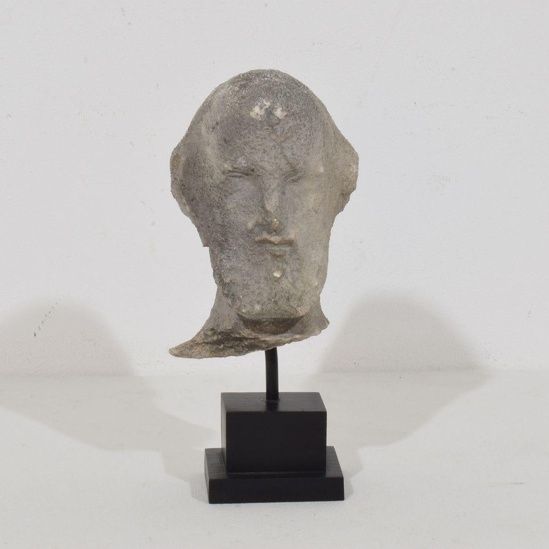 Graziosa testa in pietra scolpita di un santo con una grande espressione. 
Francia, circa 1750. Le misure includono la base in legno
H. H. 20cm  L:8,5 cm P:10,5 cm 