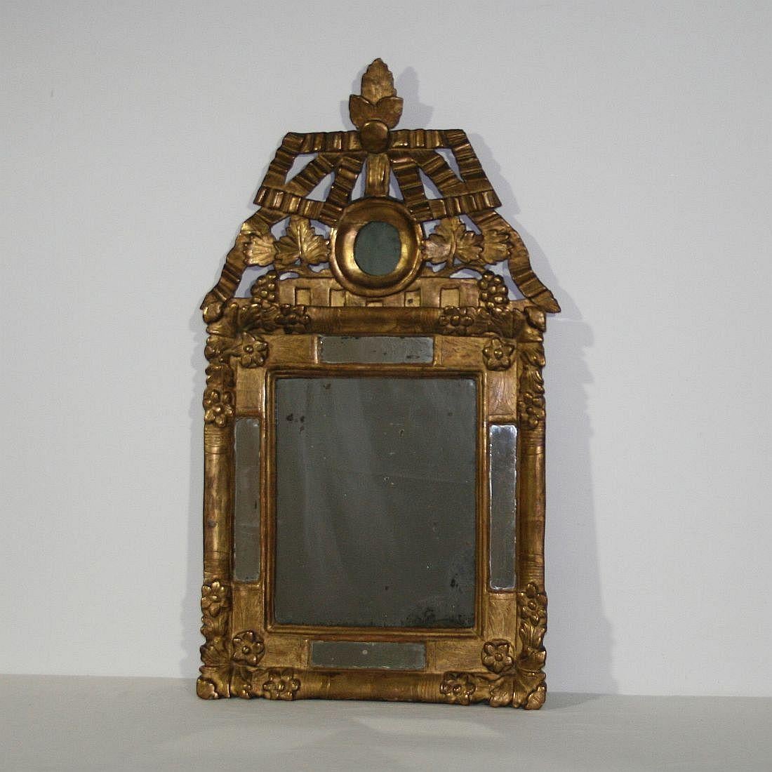 Stunning period piece with original color, gilding and mirror glass, France, circa 1700-1750. Weathered, small losses and old repairs at the small cracks in the crest.