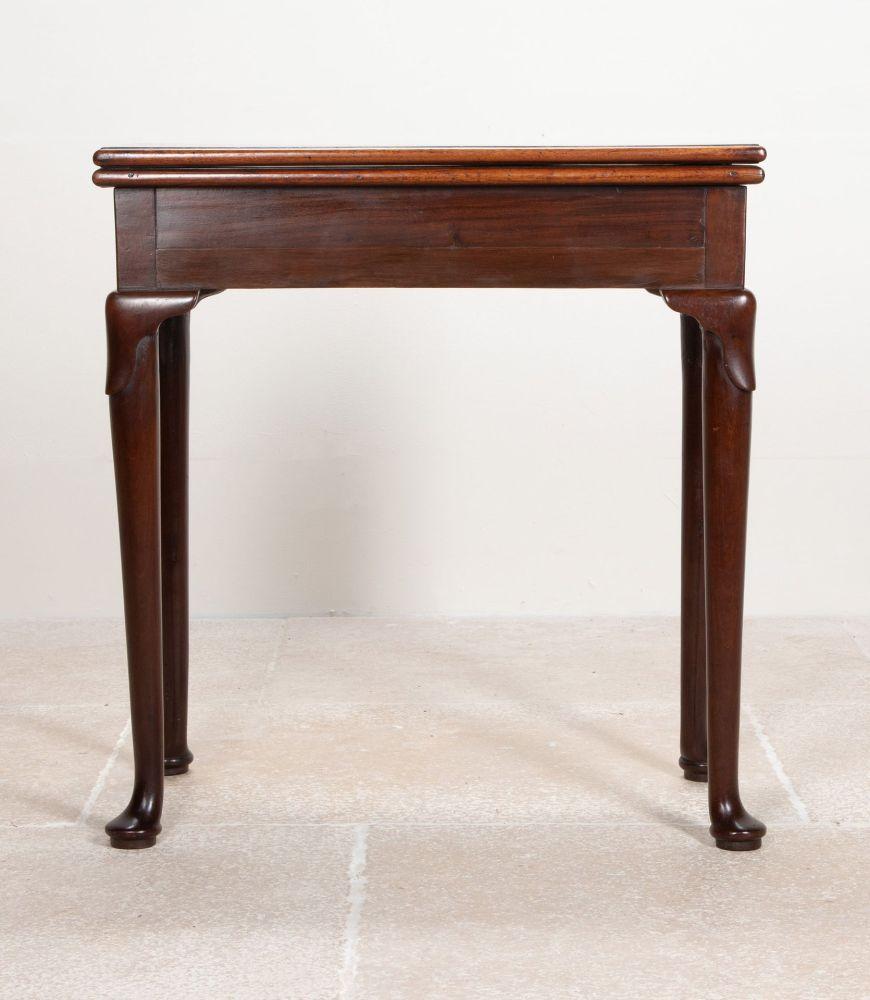 Preciosa mesa de té inglesa de caoba del siglo XVIII, época de Jorge II, de proporciones deliciosamente pequeñas. 
La parte superior abatible se abre para revelar una tapa pulida de doble tamaño. Sobre patas torneadas y ahusadas, con rodillas