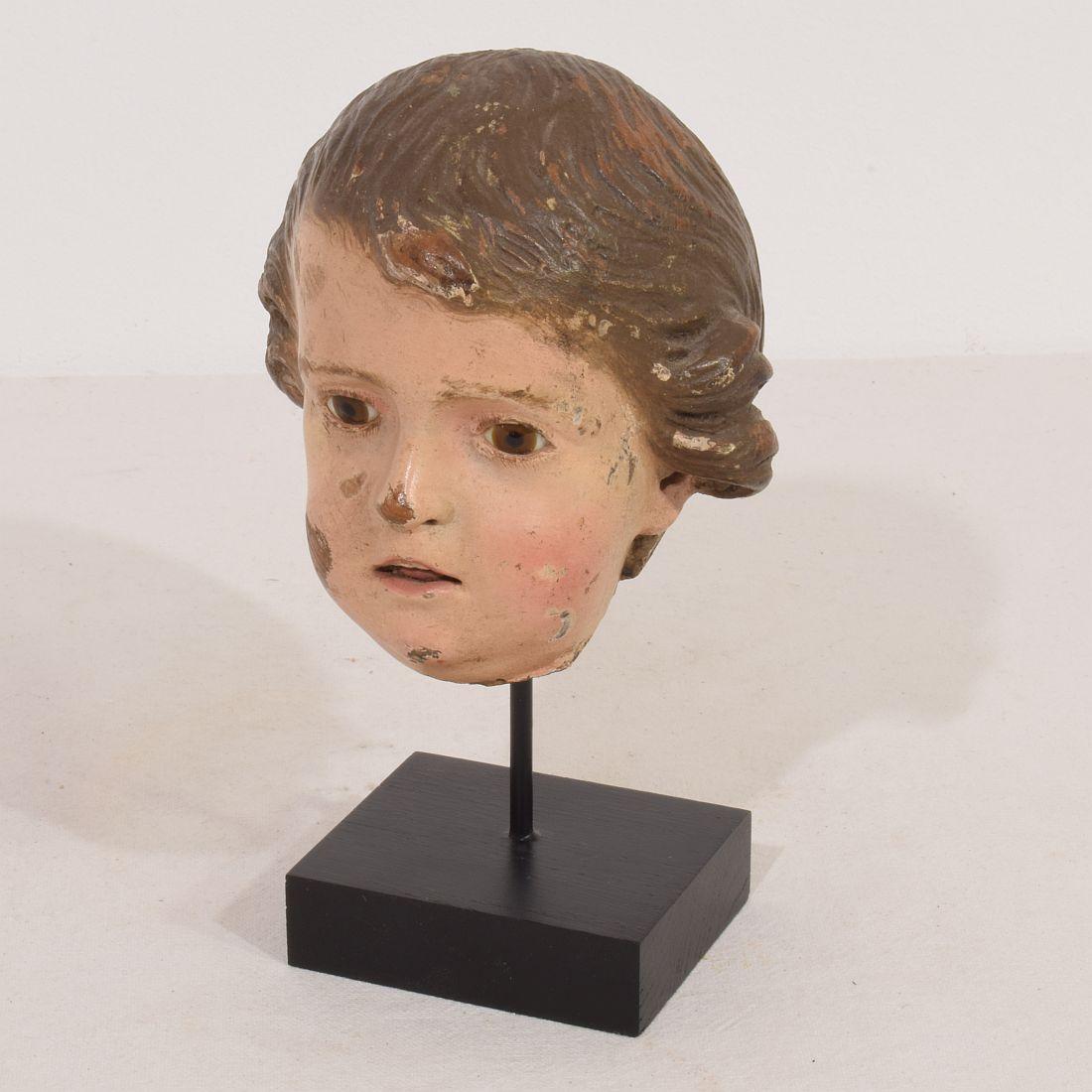 Stunning handcarved wooden head fragment with beautiful expression and glass eyes,
Italy, circa 1750-1800. Beautiful example of 18th century craftsmanship.
Weathered 
Measurement here below is inclusive the wooden base.