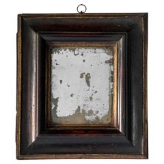 Small 18th century Italian ebonized molded and part-gilt mirror