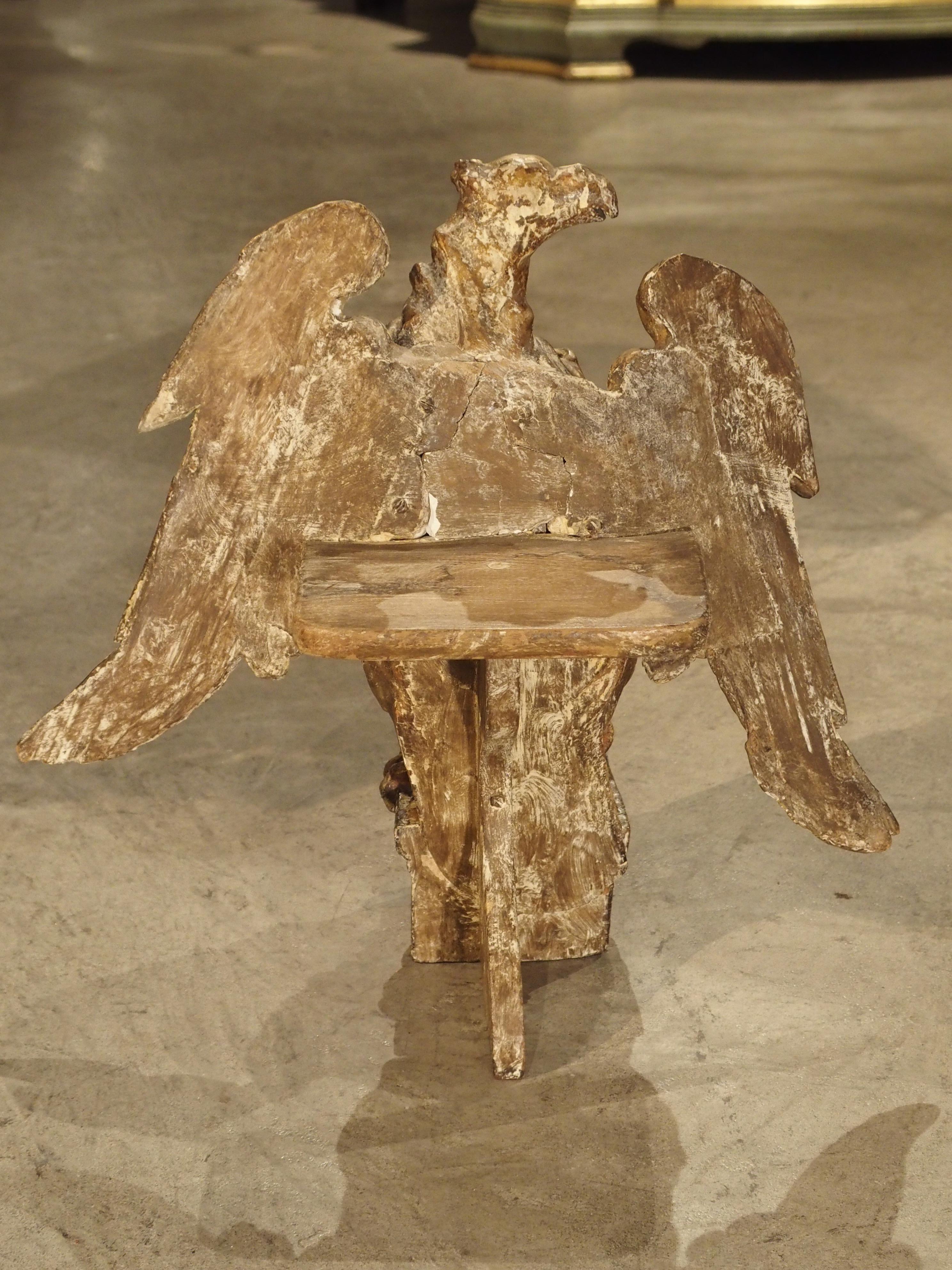 From the 1700s, this hand-carved Italian eagle is holding a cartouche with his right foot while his left foot clutches the platform beneath him. We believe this platform would have been placed into another element as there is a hole going all the