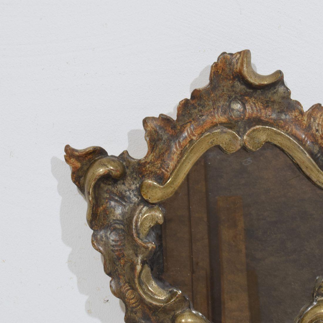 Schöner kleiner handgeschnitzter Barockspiegel aus Holz, mit seiner originalen verwitterten Silbervergoldung.
Italien, um 1750. Verwittert 
H:26,5cm  B:23cm T:3cm 