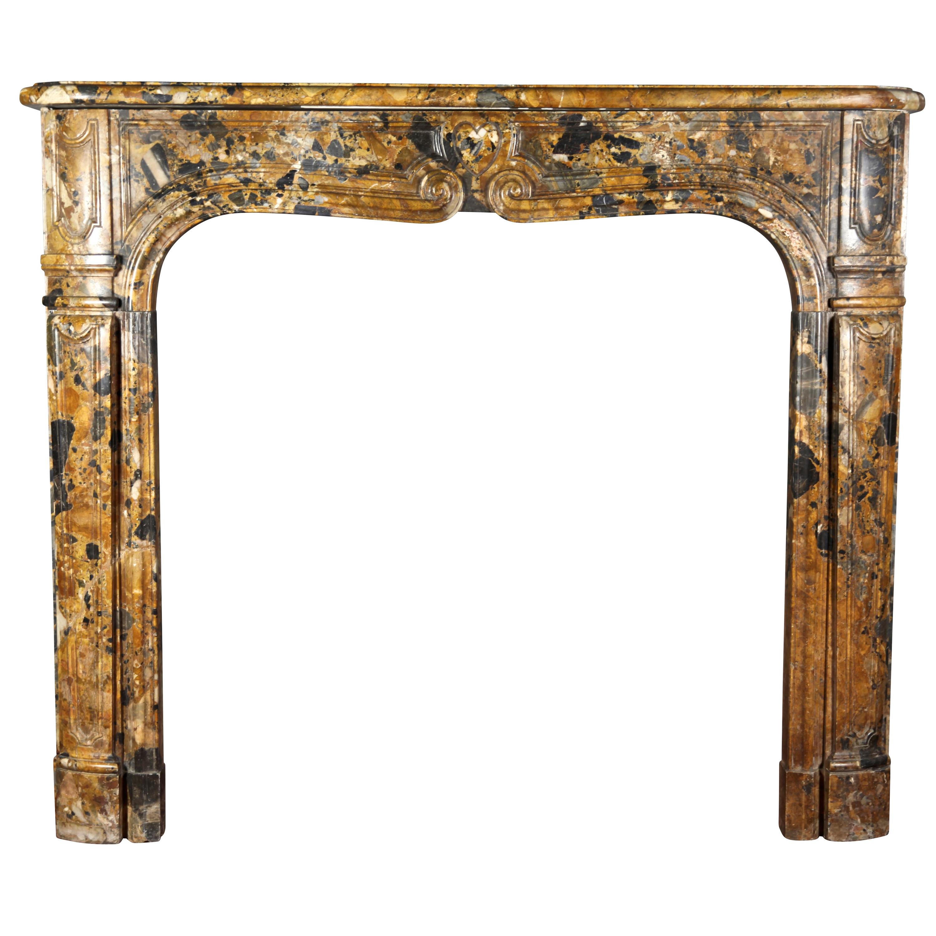 Petite Italian antique chimney piece is in Royal Brêche marble and has its original patina. The front has a heart motif. This particular is a 