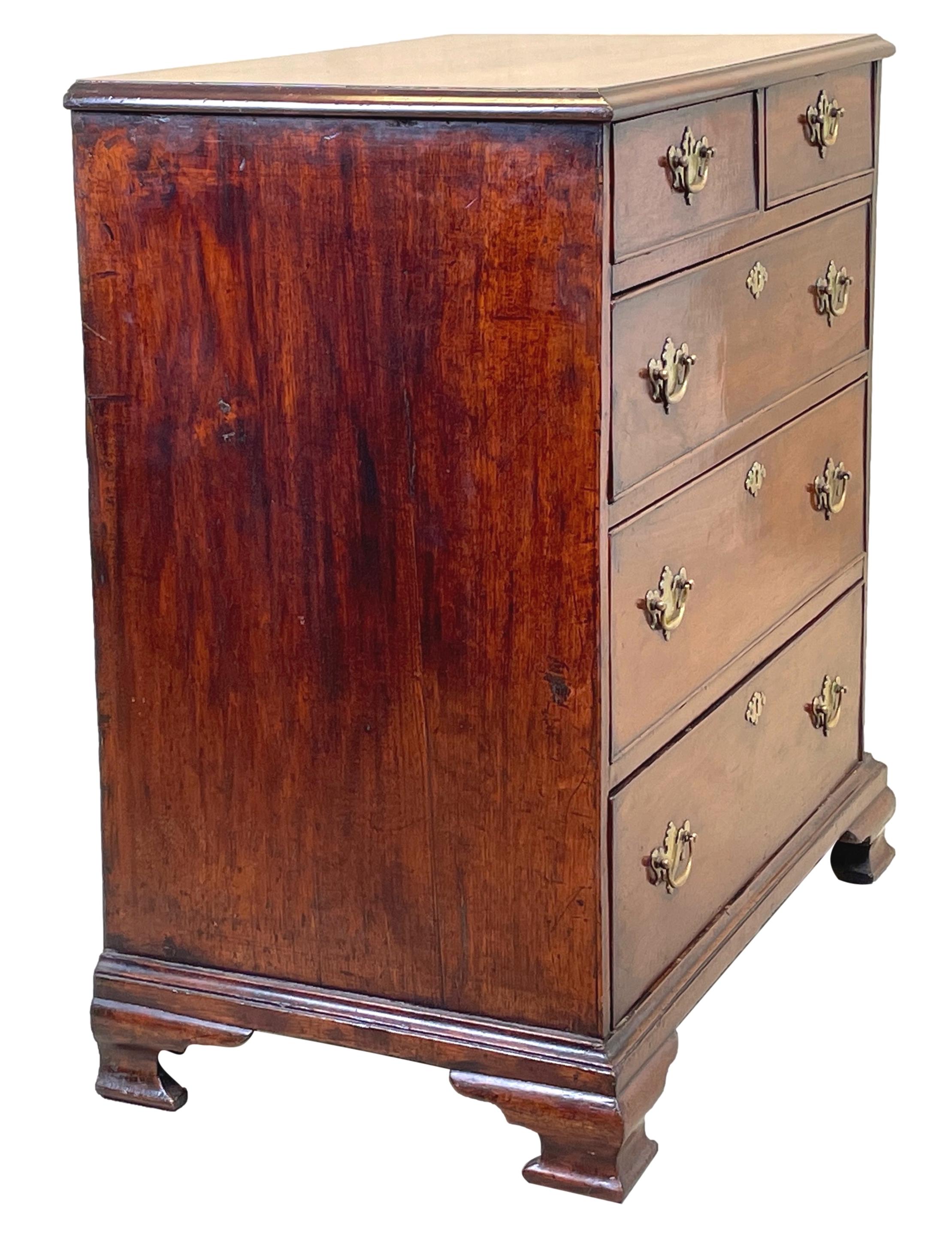 A Very Attractive George II Period Mahogany Chest, Of Diminutive Proportions, Having Superbly Figured Top Over Two Short And Three Long Drawers, With Replacement Brass Handles, Raised On Elegant Original Ogee Bracket Feet. 

This fabulous little