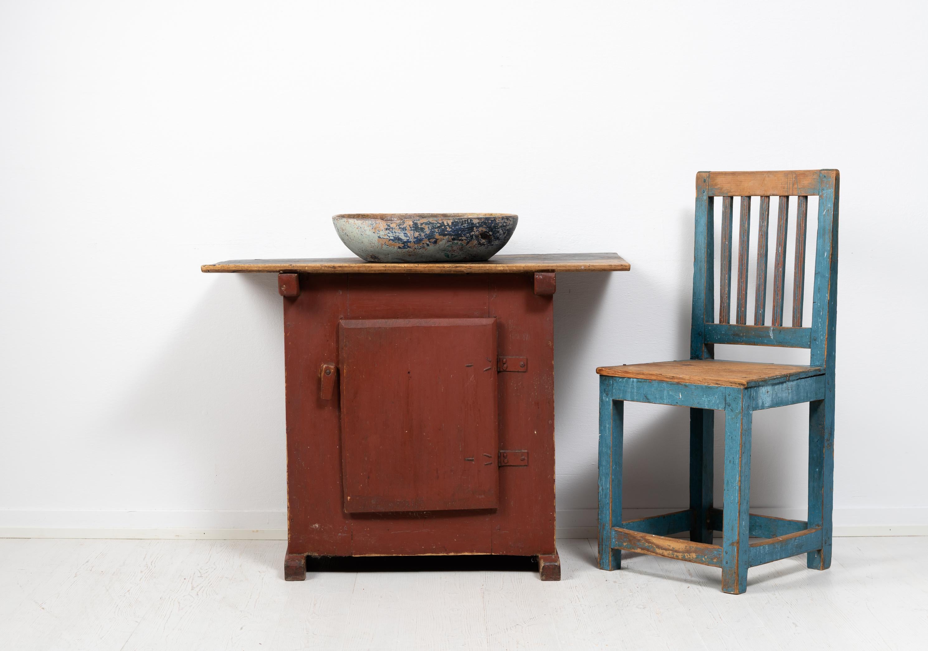 Small cabinet or side table in folk art from the late 1700s. The table is a naive rustic folk art furniture from Sweden and would work well as both a wall table, nightstand or as a small cabinet. It is painted pine with the original first layer of