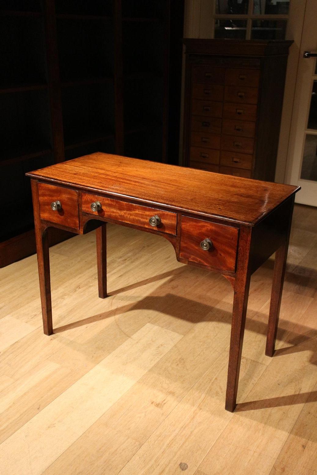 Beautiful small antique Mahogany console table with 3 drawers. The table can also be used as a writing table. The top has a subtle inlay. This specific inlaid edge is called cross banded in English. The table has a beautiful patina. Beautiful and