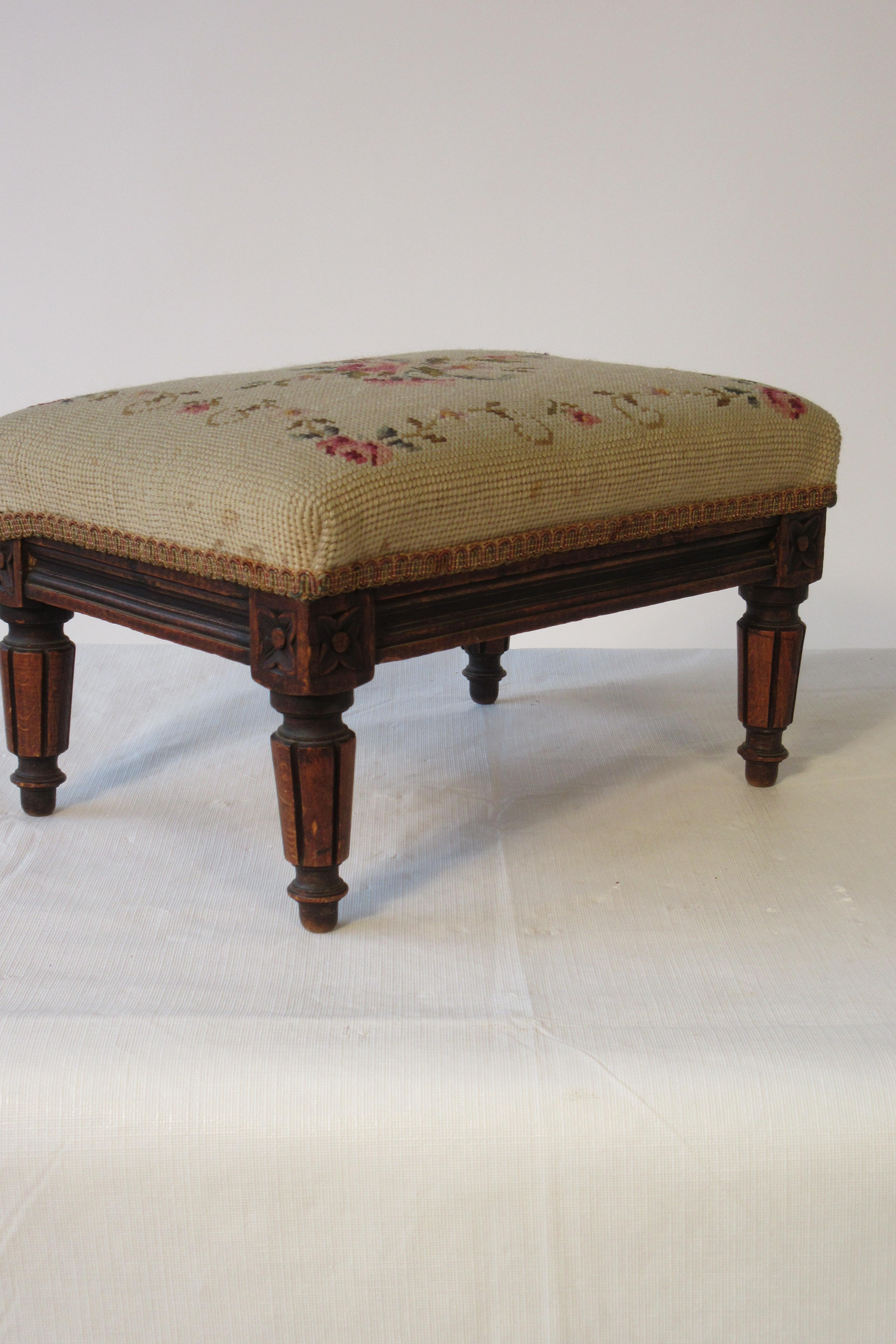 Turn of the century French carved wood footstool. Needlepoint cushion. Needs reupholstering.