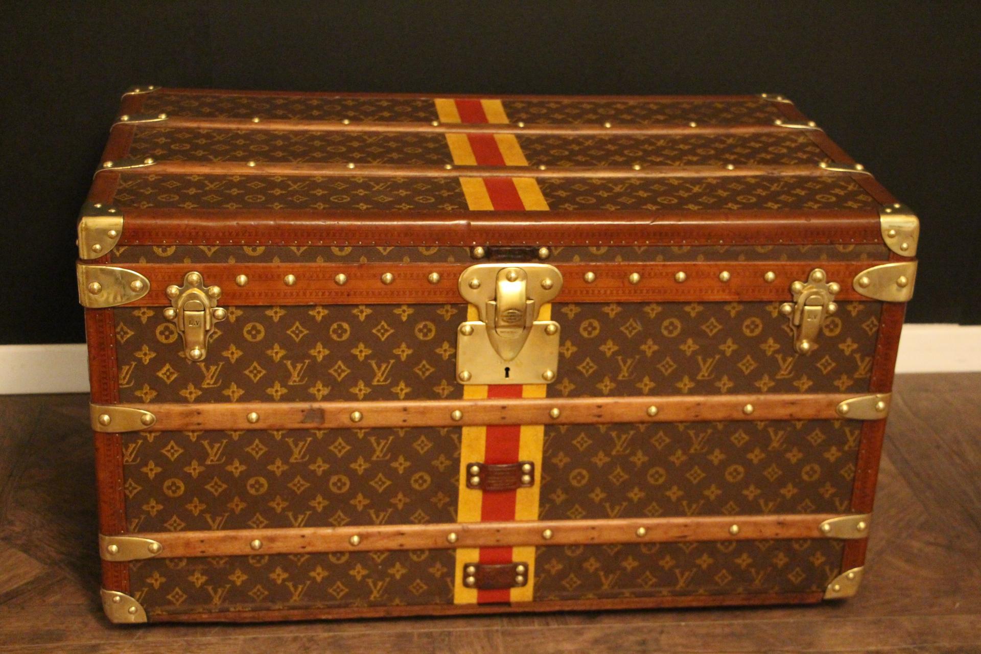 This superb Louis Vuitton steamer trunk features stenciled monogram canvas, honey color lozine trim, LV stamped solid brass locks, latches and studs as well as leather side handles and brass corners. Its customized painted yellow and red stripes add