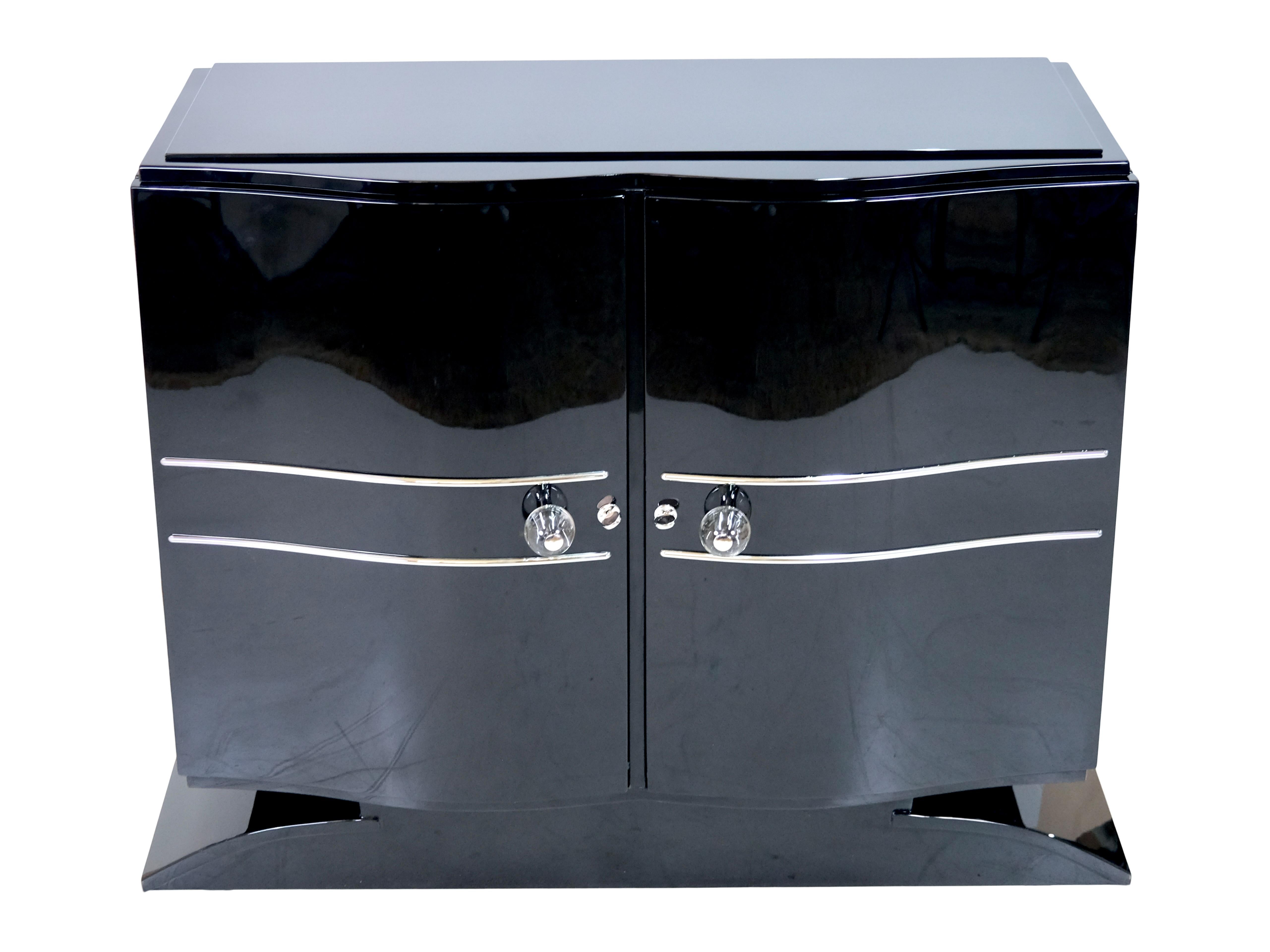Sideboard with curved front
Two hinged doors
Piano lacquer, black high gloss

Original Art Deco, France 1930s

Dimensions:
Width: 120 cm
Base width: 131 cm
height: 105 cm
Depth: 44 cm