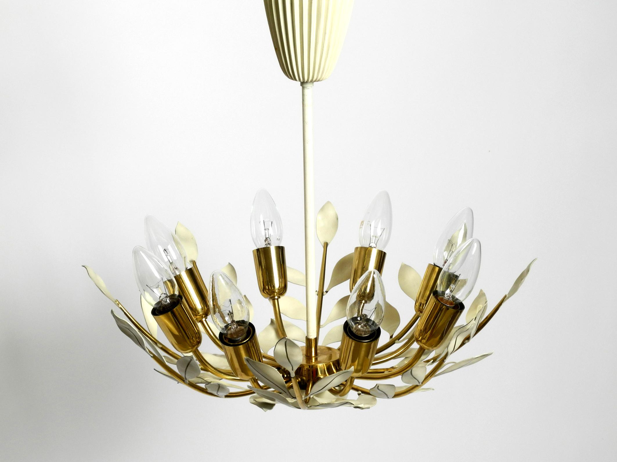 Small rare Mid Century brass Sputnik ceiling lamp with 8 arms.
Manufacturer is Vereinigte Werkstätten. Made in Germany.
Beautiful floral design with white painted leaves. Very rare in this small version. The entire lamp is made of brass including