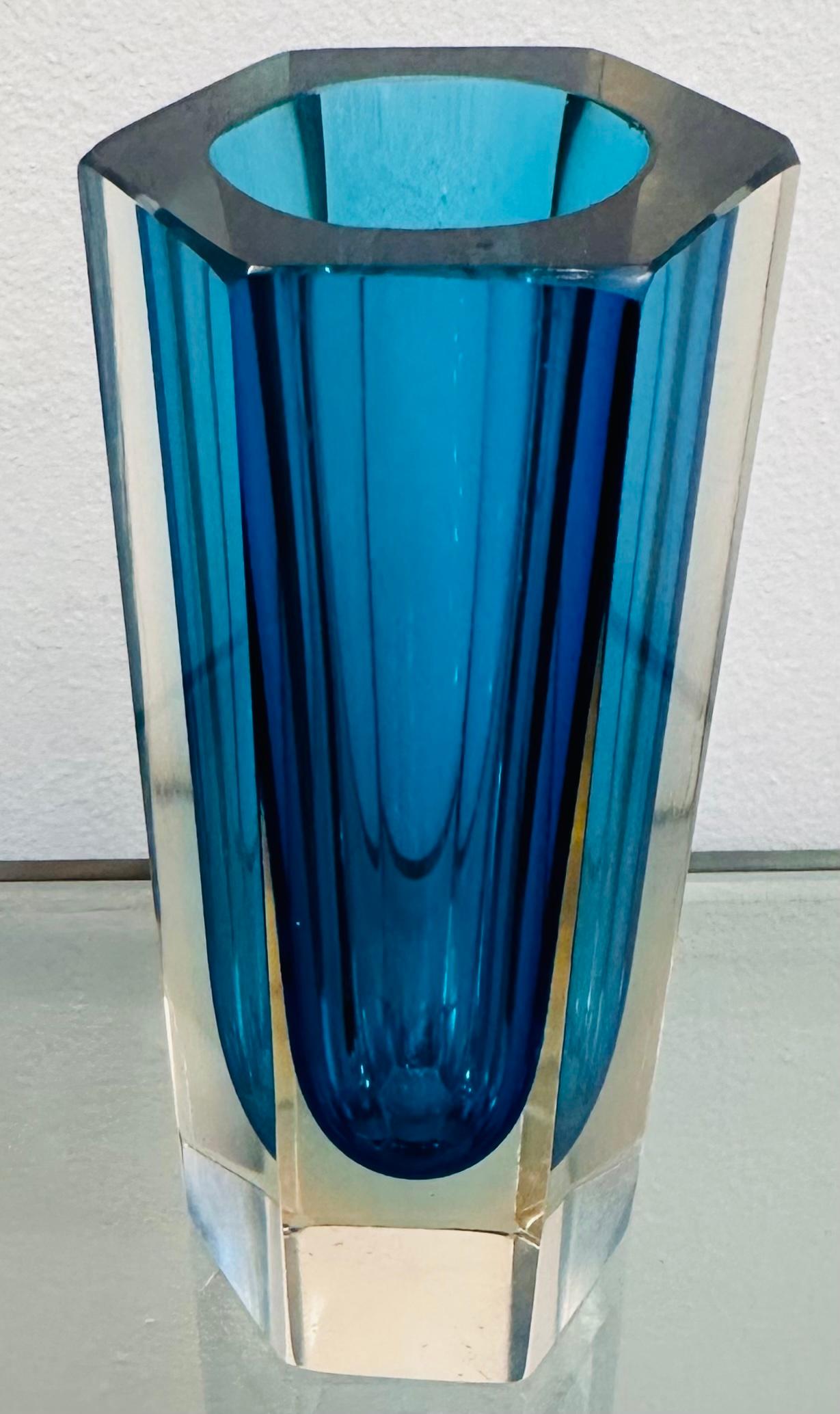 A small Italian Murano hexagonal turquoise encased in clear glass vase. A beautiful decorative piece perfect for a glass display case or shelf where the light can shine through it to emphasise the beautiful coloured glass. The vase is in very good