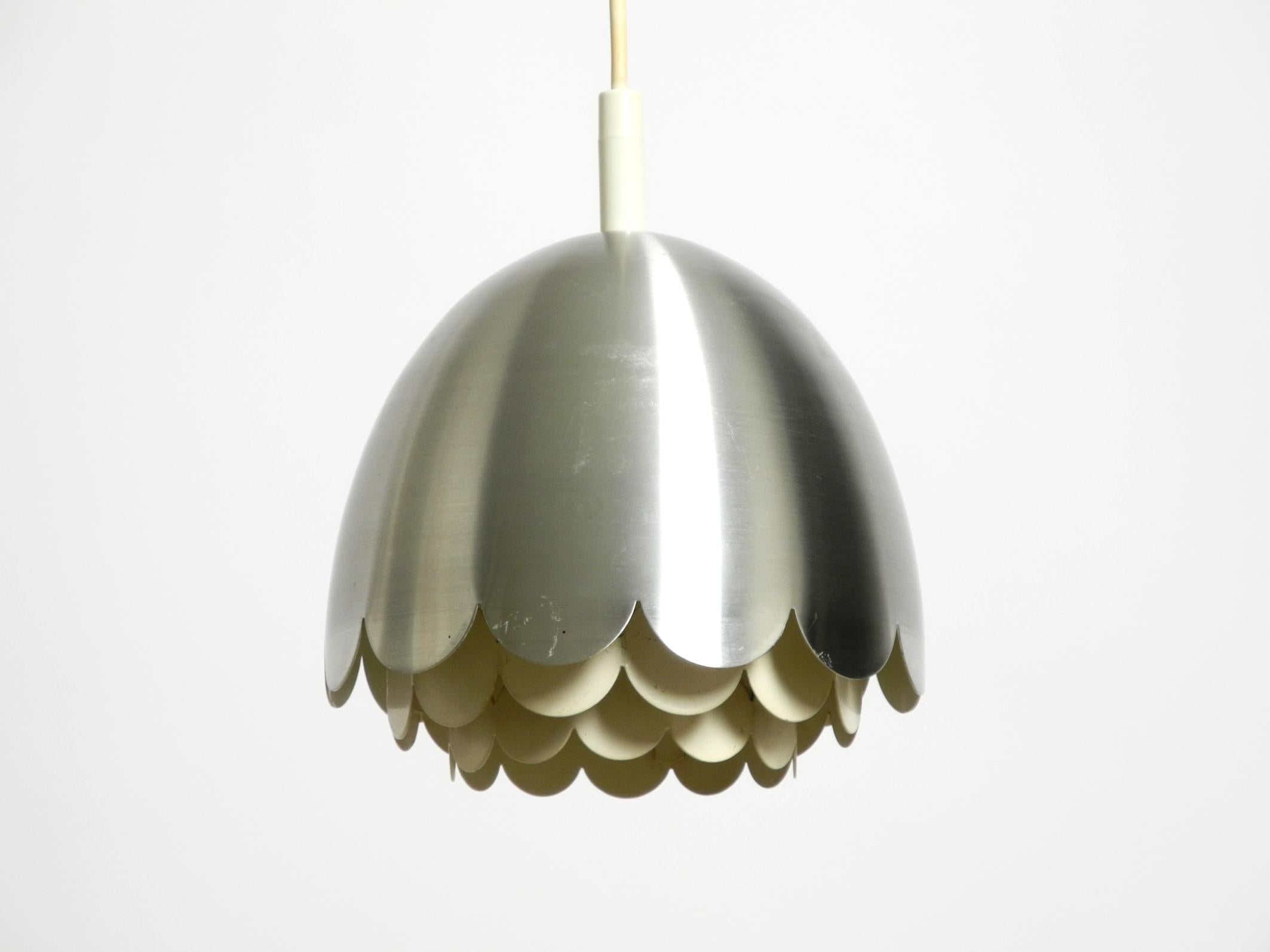 Beautiful small, original 1960s Space Age pendant lamp by Doria.
The outer shade is made of aluminum. The inner diffuser is made of white-painted metal.
The entire lamp is in very good condition for its age, approximately 60 years.
No bumps or dents