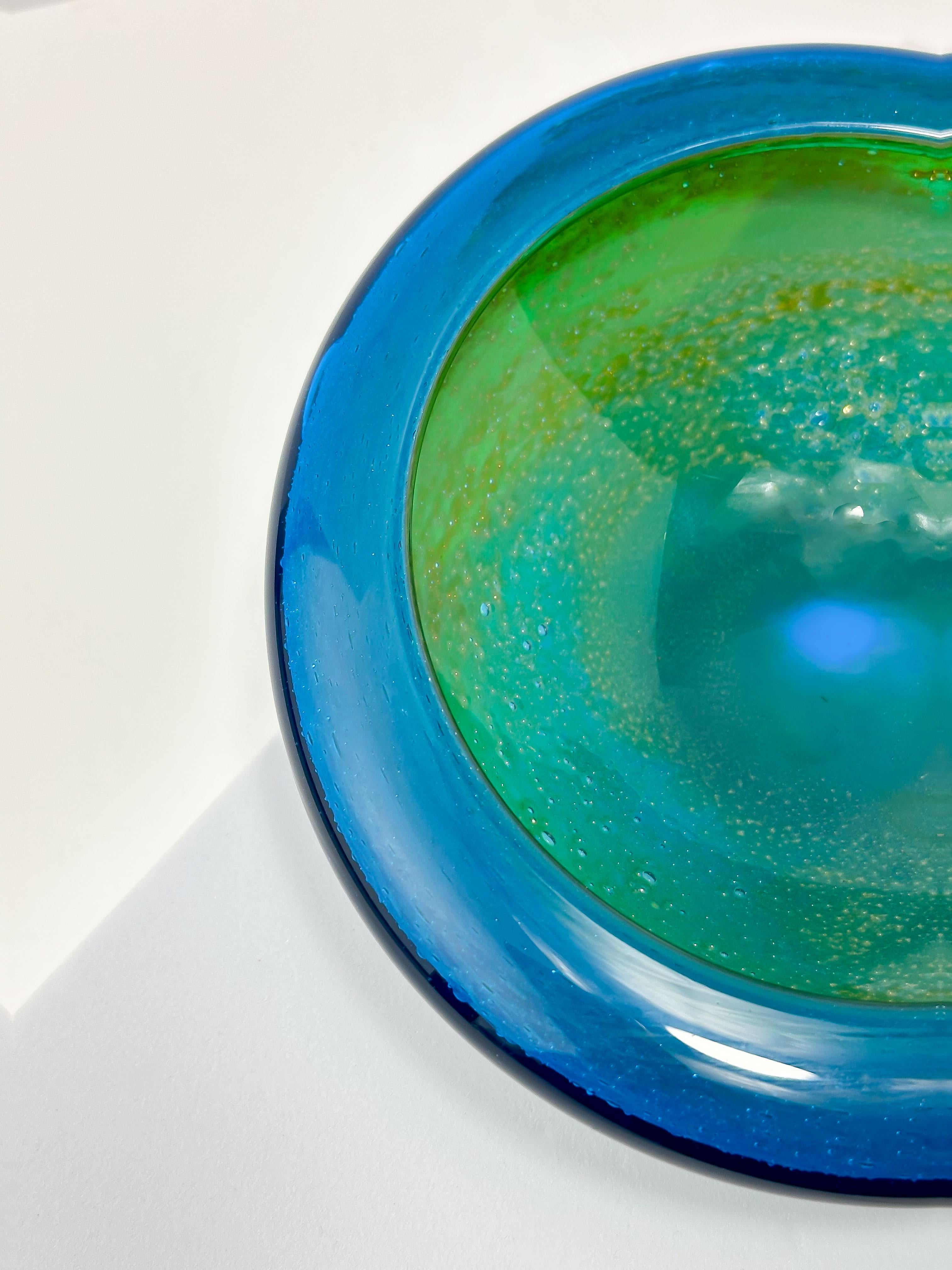 Eine kleine runde Glasschale, die in den frühen 1970er Jahren von Michael Harris hergestellt wurde.  Dieses Stück gehört zu Harris' frühen Arbeiten für Mdina und ist damit ein seltenes Stück Glasgeschichte. 

Er hat eine kleine runde Basis und einen