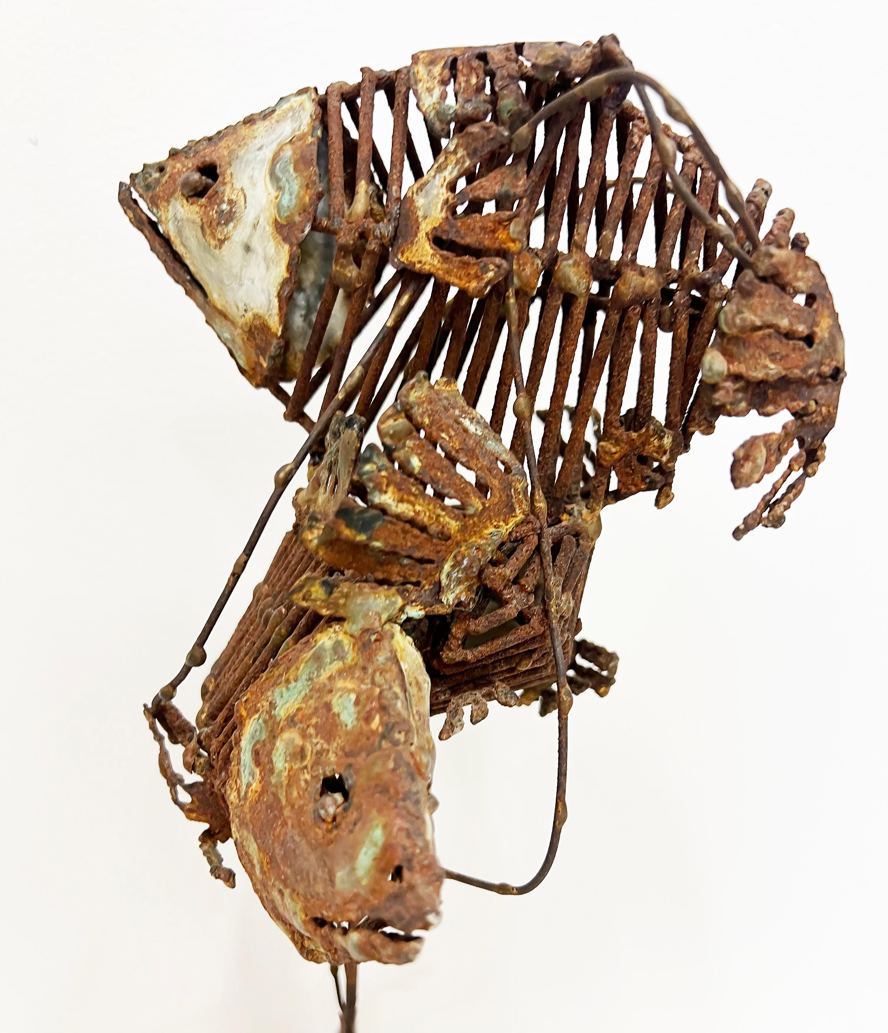 Small 1970s Brutalist Fish Bones Tabletop Sculpture on a Wood Base

Offered for sale is a small but dramatic 1970s Brutalist tabletop sculpture of 2 fish skeletons swimming in opposite directions. The fish swim above a wood block base. The sculpture