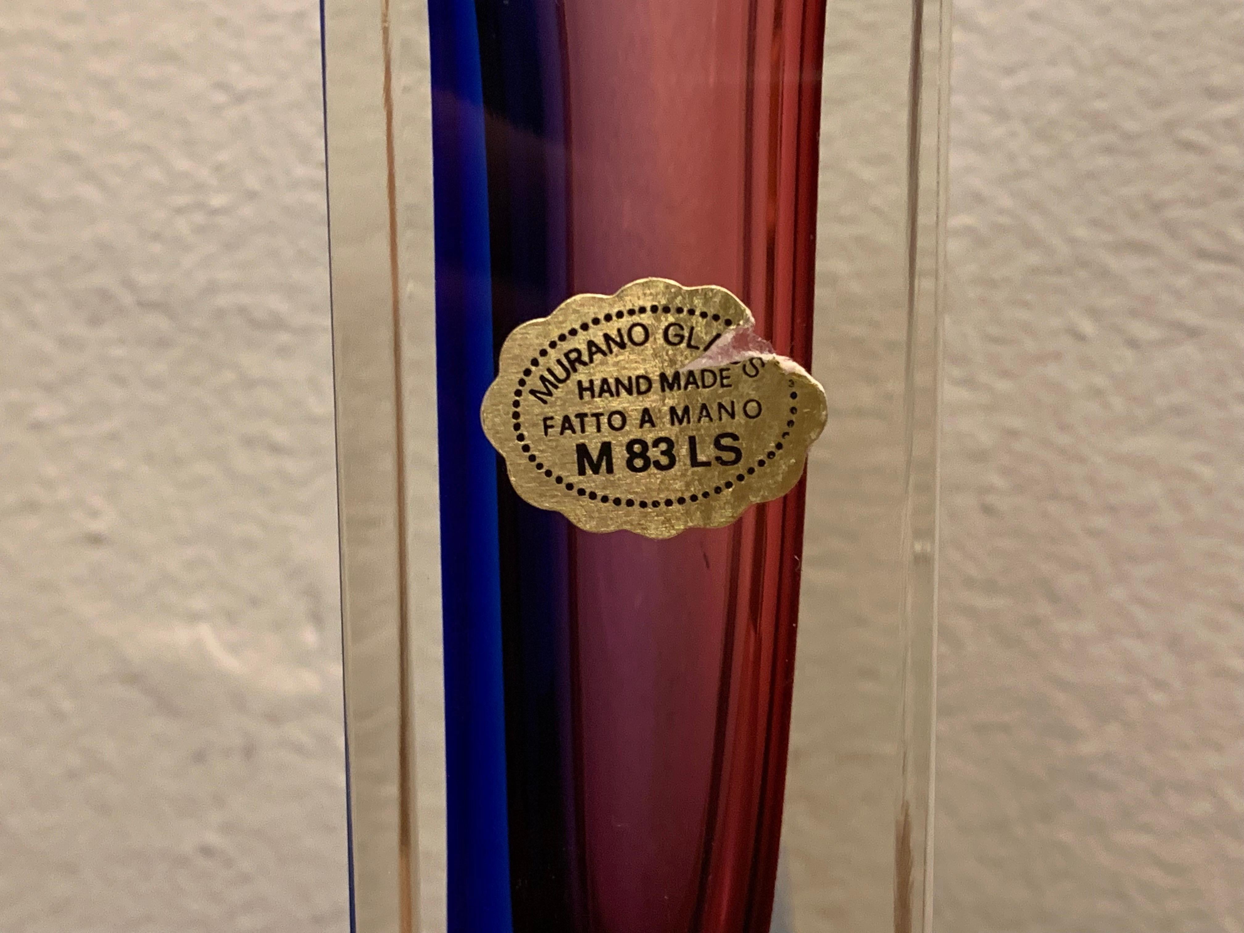An interesting vintage, Murano, handmade sommerso purple, blue and clear glass vase. The original sticker is visible on one side marked: Murano Glass, Hand Made, Fatto A Mano, M 83 LS. A beautiful decorative piece perfect for a glass display case or