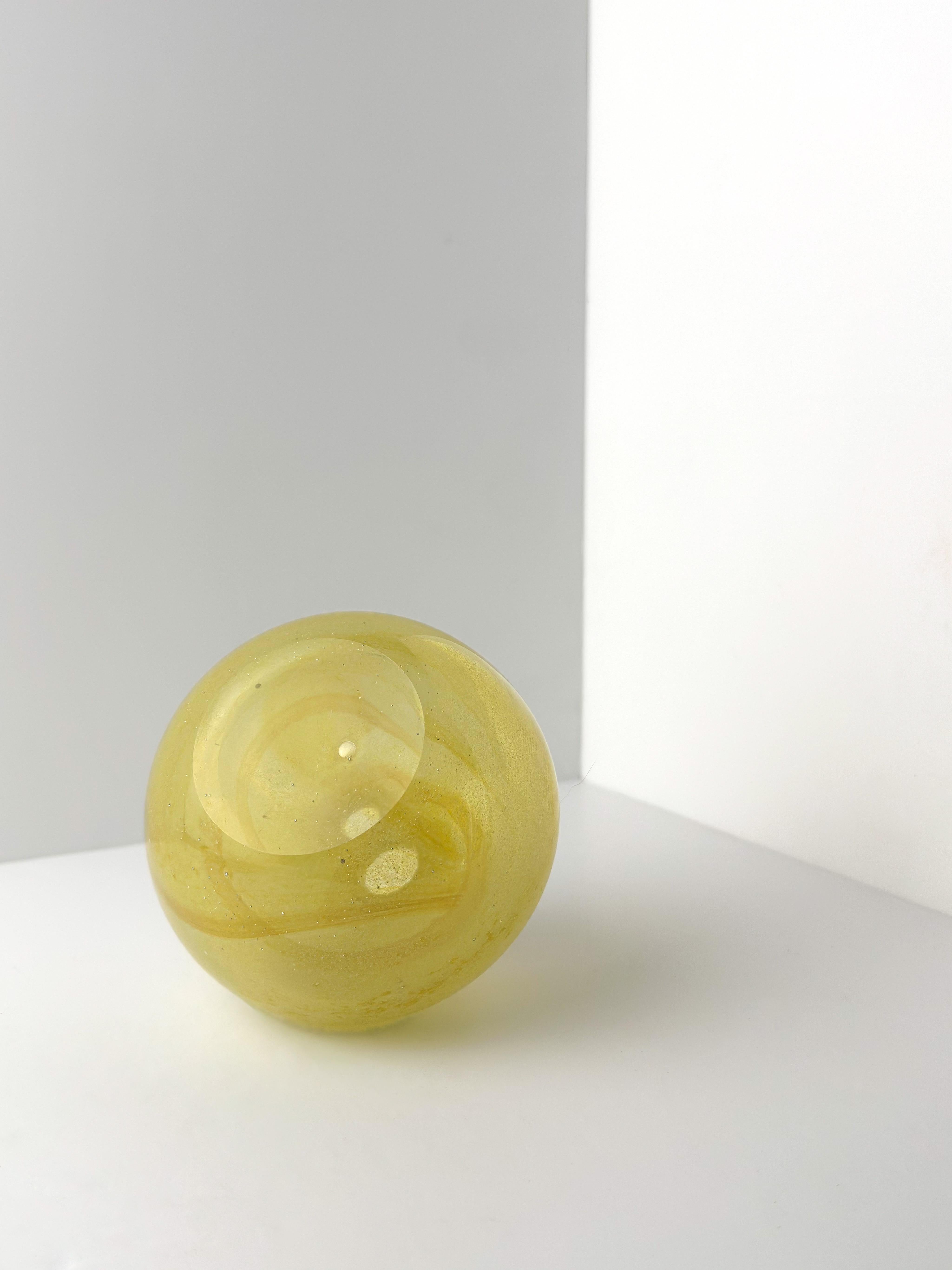 A small yellow art-glass bottle vase by Michael Harris; an early piece of his work for Mdina, crafted at the beginning of the 1970s. 

It has a small, spherical, rotund body, protruding outwards and upwards, wonderfully juxtaposed with a narrow neck