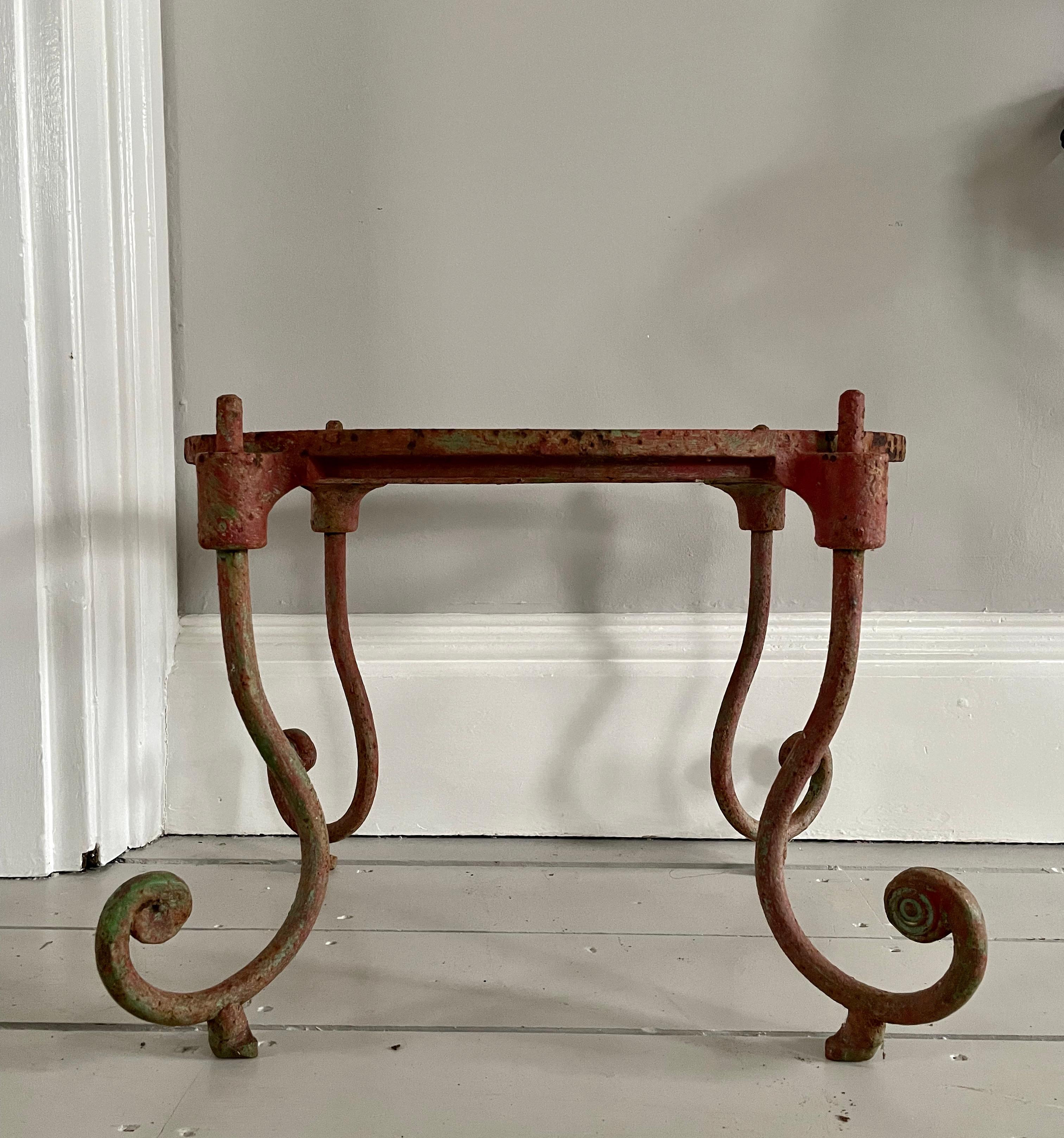 This substantive iron table base is a real honey and would be fabulous topped with a marble slab or thick glass top. In its original (and now faded) red-over-green paint with minor surface rusting, the lines are sinuous and the construction very