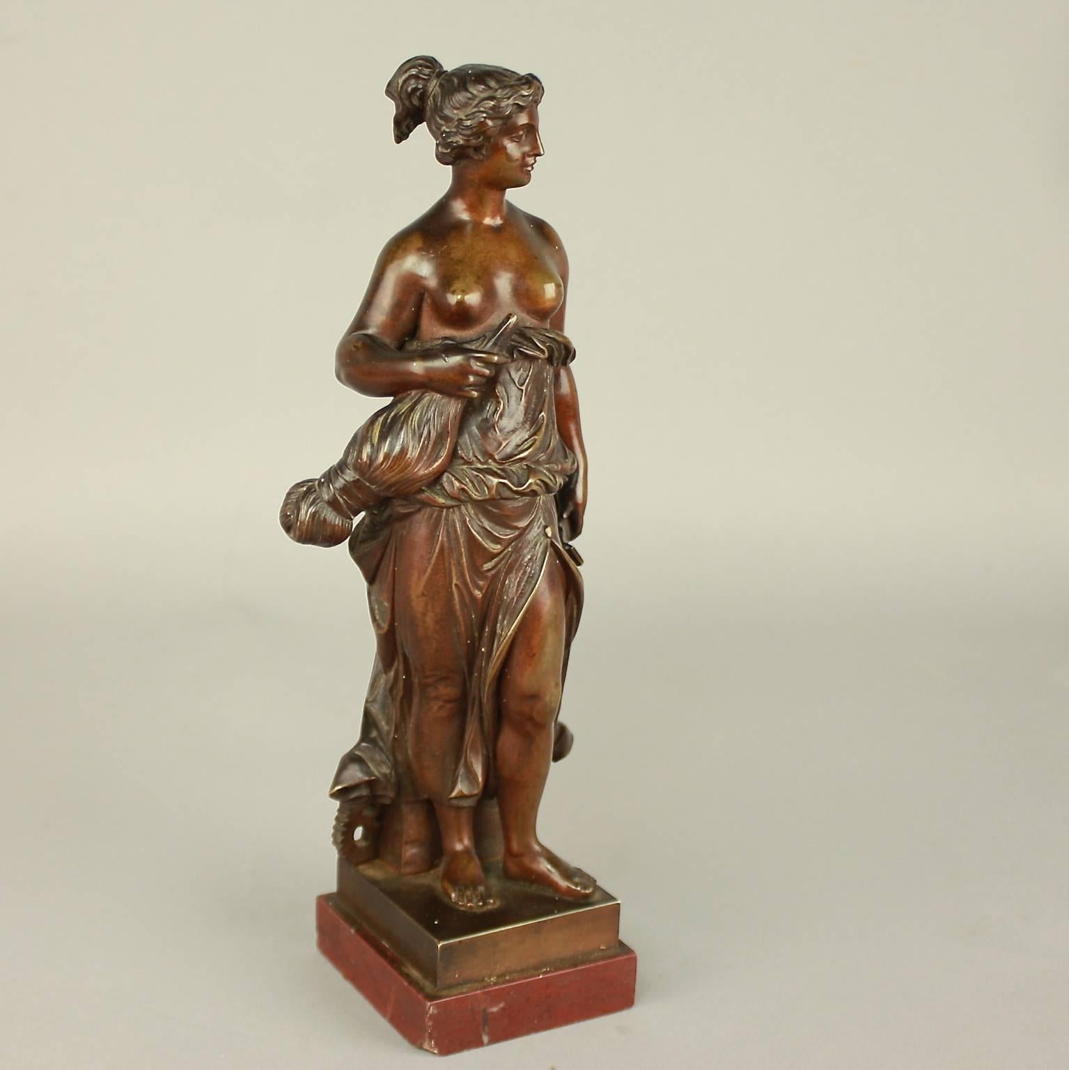 Kleine patinierte weibliche Bronzefigur aus dem 19. Jahrhundert, die eine Allegorie der Manufaktur mit einer Spindel, einem Hammer und einem Zahnrad darstellt. Die weibliche Figur hält ihre helle Tunika hoch und schaut zuversichtlich nach vorne.