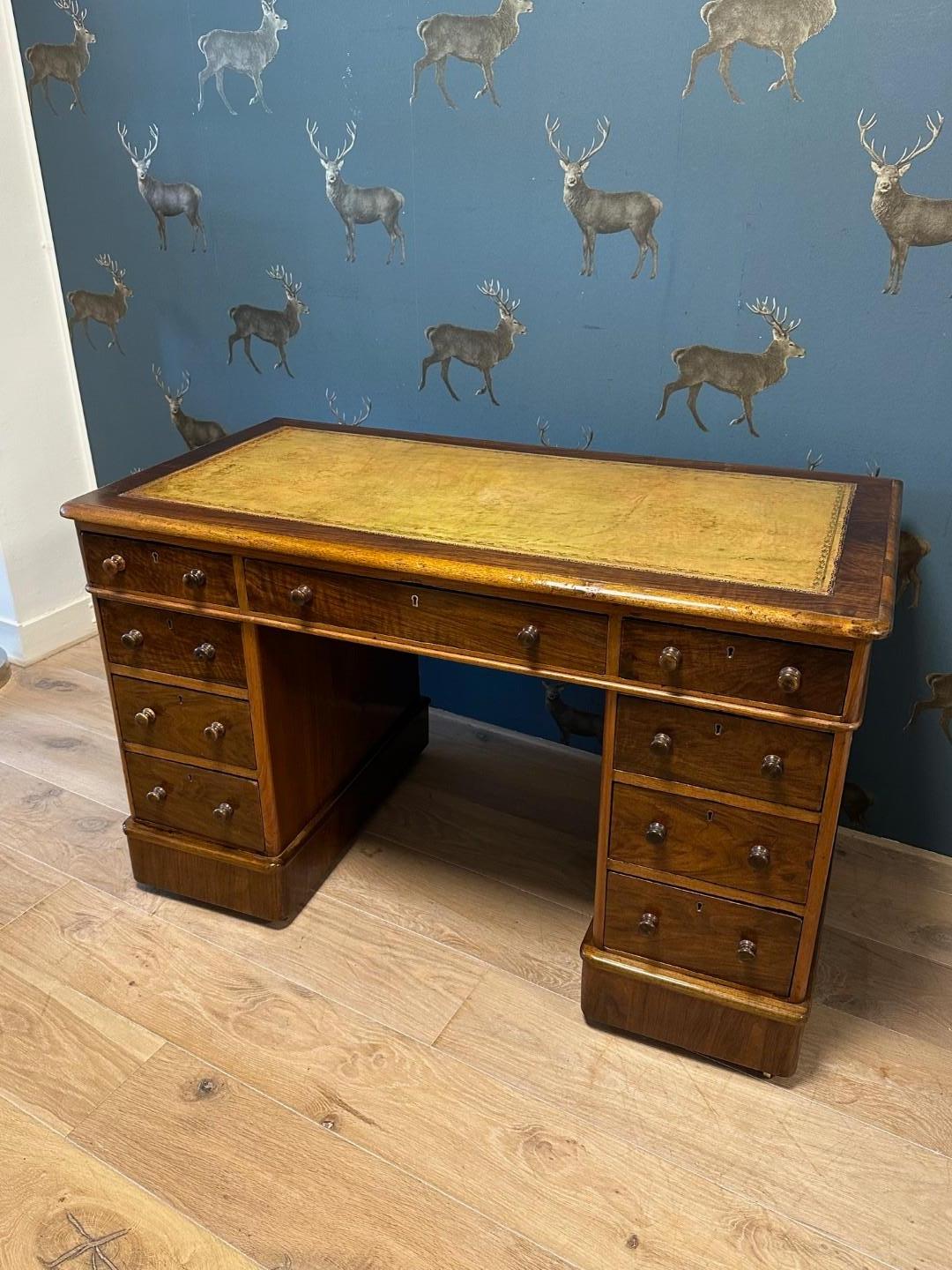 Beautiful small pure antique desk with warm lived-in Patina The  walnut has a very warm color. Beautiful tan color gold-edged leather top. Leather is in one piece. Perfect quality and completely in original condition.

Origin: England
Period: Ca.