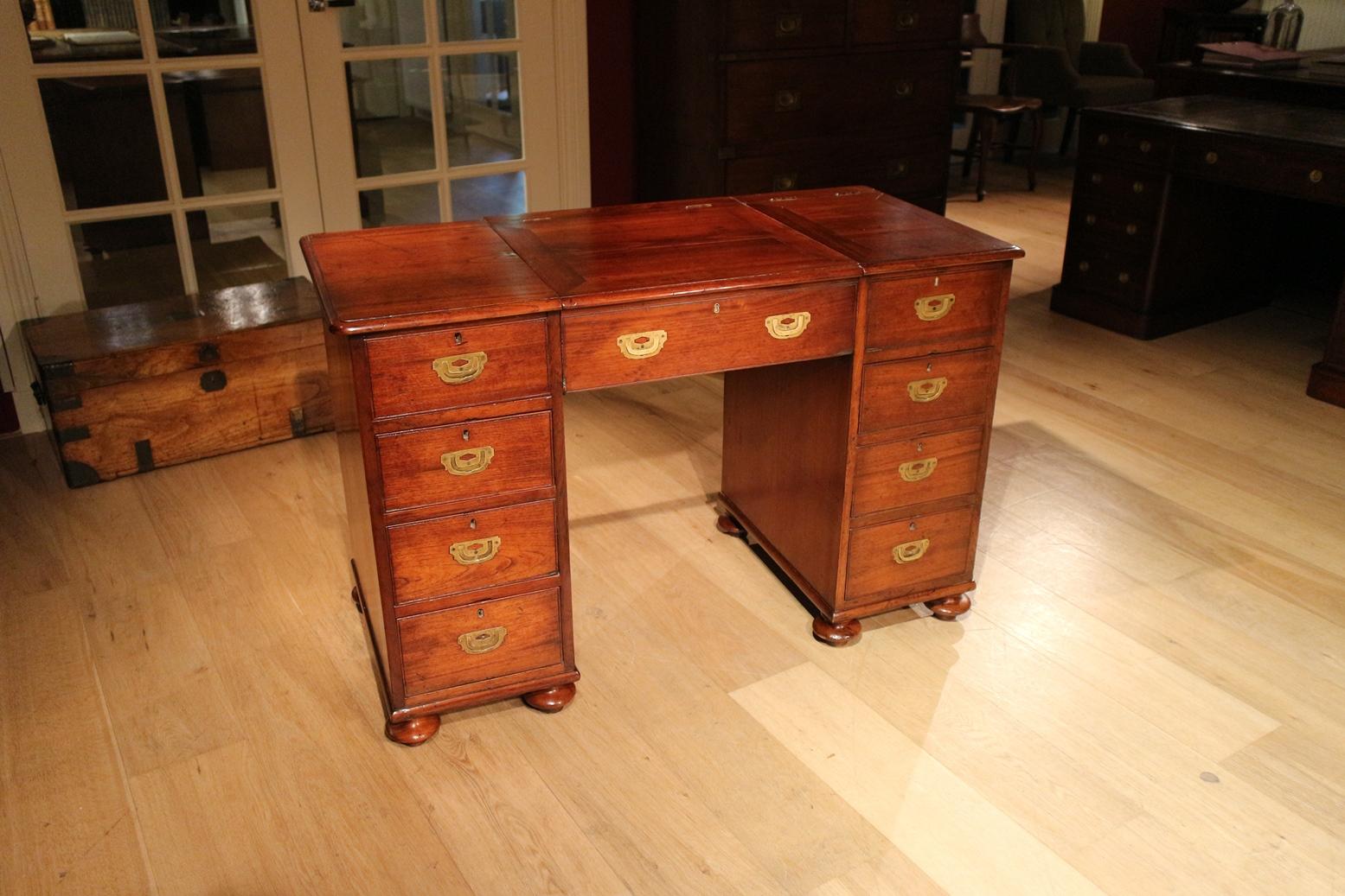 Beautiful small antique teak Campaign desk. The small agency is a real Campaign desk that went along on the campaigns. Due to the limited size, this was easy to transport. The structure is also slightly different from a traditional desk. These are 2