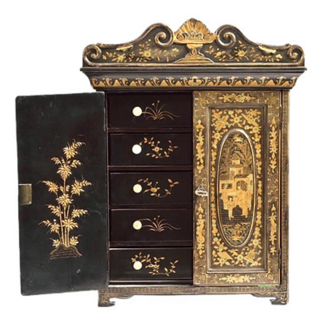 A Chinese export black and gilt lacquered cabinet, 19th century.
The carved cornice painted with flowers, above two doors decorated with chinoiserie scenes opening to five drawers
The sides with gilt floral design
Top and back plain black
H 49