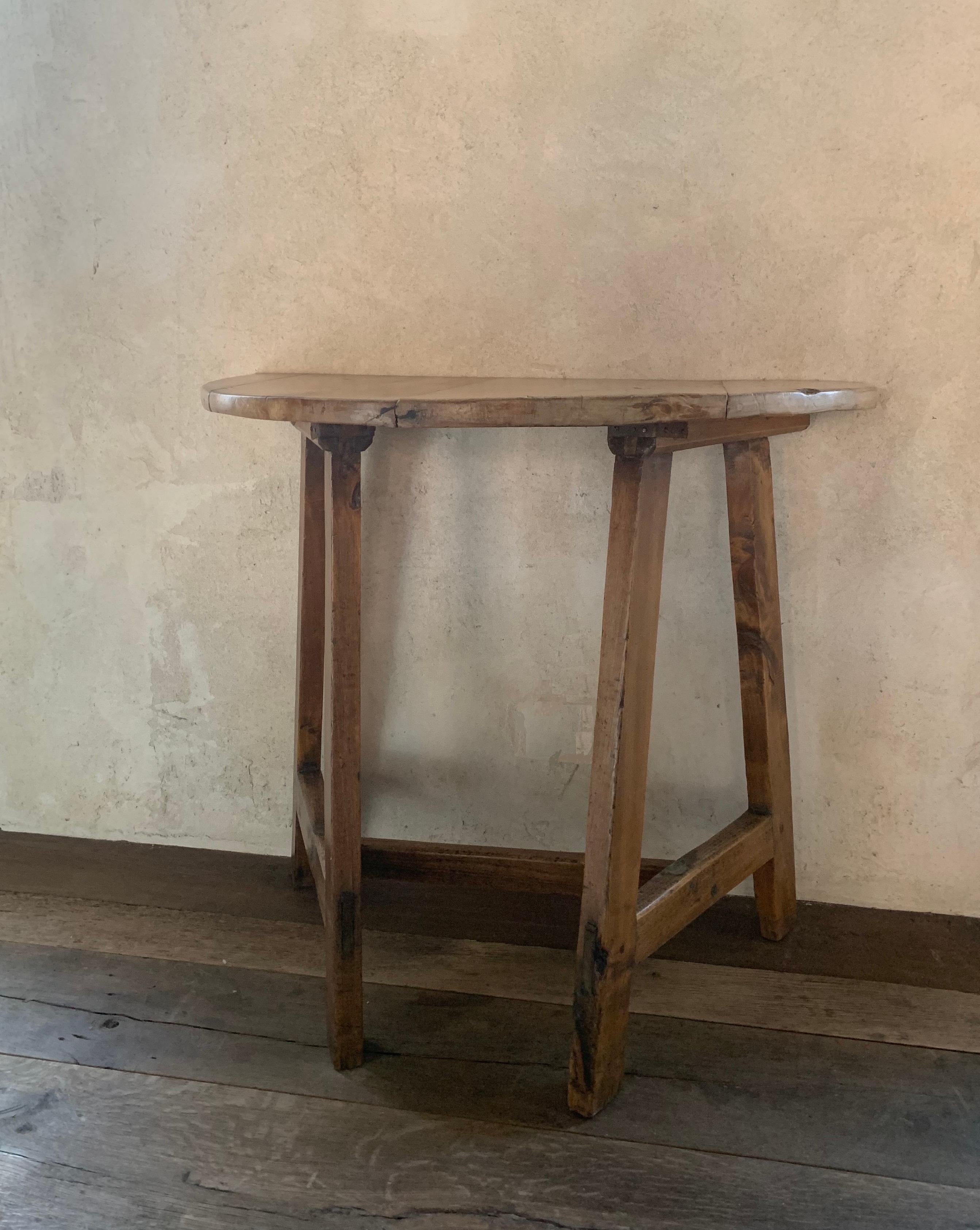 A early 19th century Spanish demilune console of small proportions. The top from poplar and the base from pine with a smooth patina and warm colours. Overall nice proportions and very sturdy.