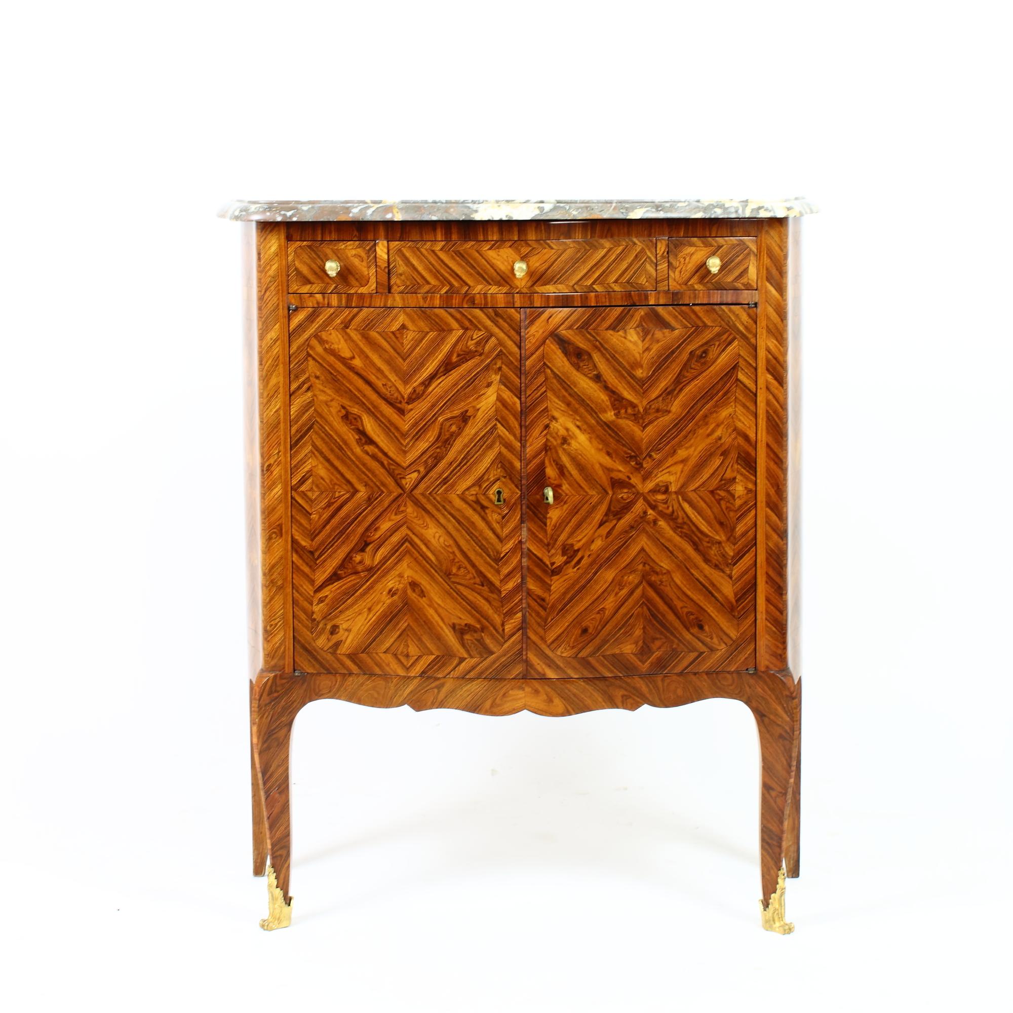 Small cabinet with curved front and sides standing on small cabriole legs with bronze sabots. Two doors with marquetry 