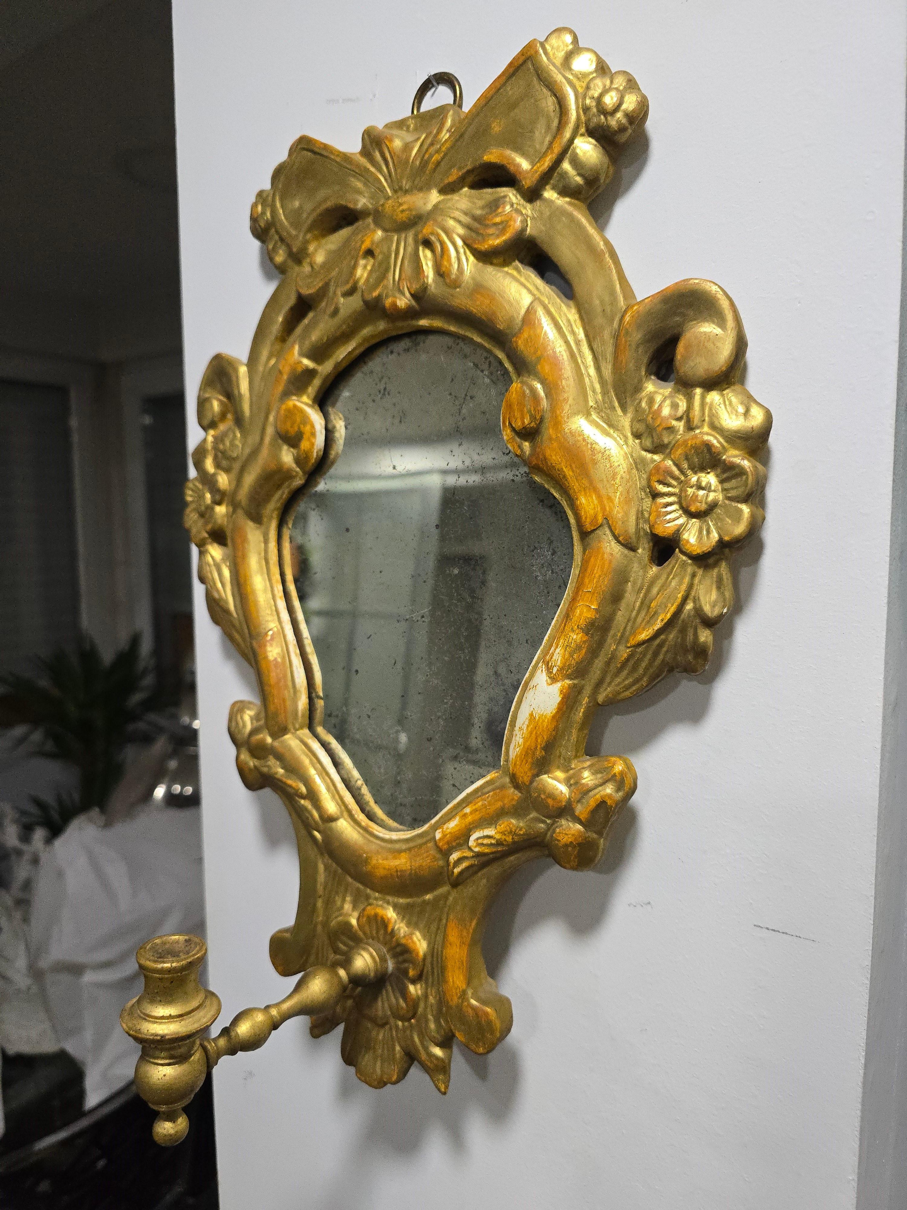 Questo squisito specchio a cornucopia di piccole dimensioni, risalente ai primi anni del 1800, è un notevole pezzo di artigianato del XIX secolo. Splendidamente intagliato in legno e impreziosito da una raffinata doratura a foglia d'oro, questo