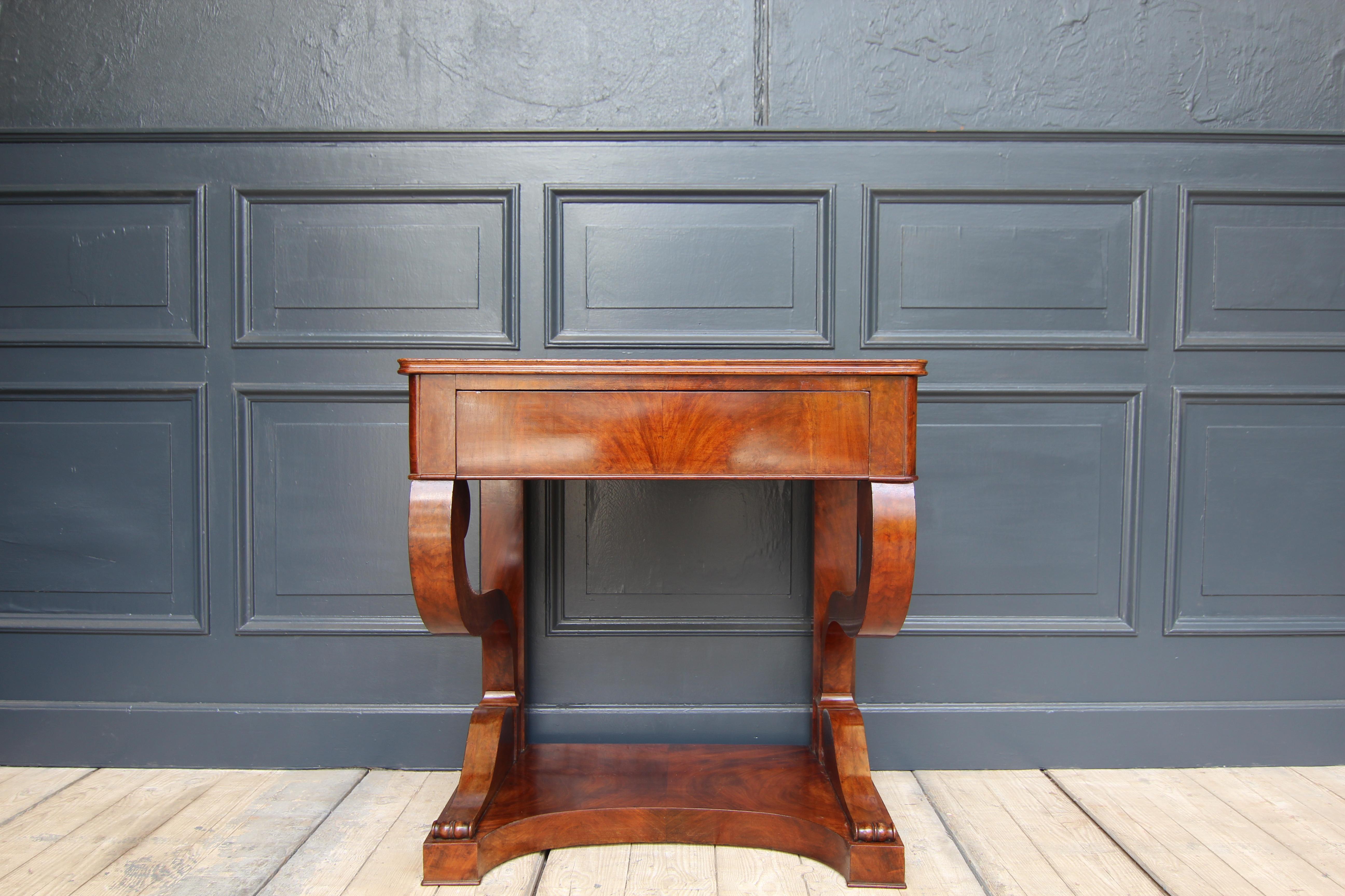 A small 19th century mahogany console or wall table.

Solid mahogany and veneered.

Curved pilasters on a plinth support the simple frame with a drawer sans traverse and a slightly overhanging profiled top.

Dimensions: 
81 cm high / 31.9