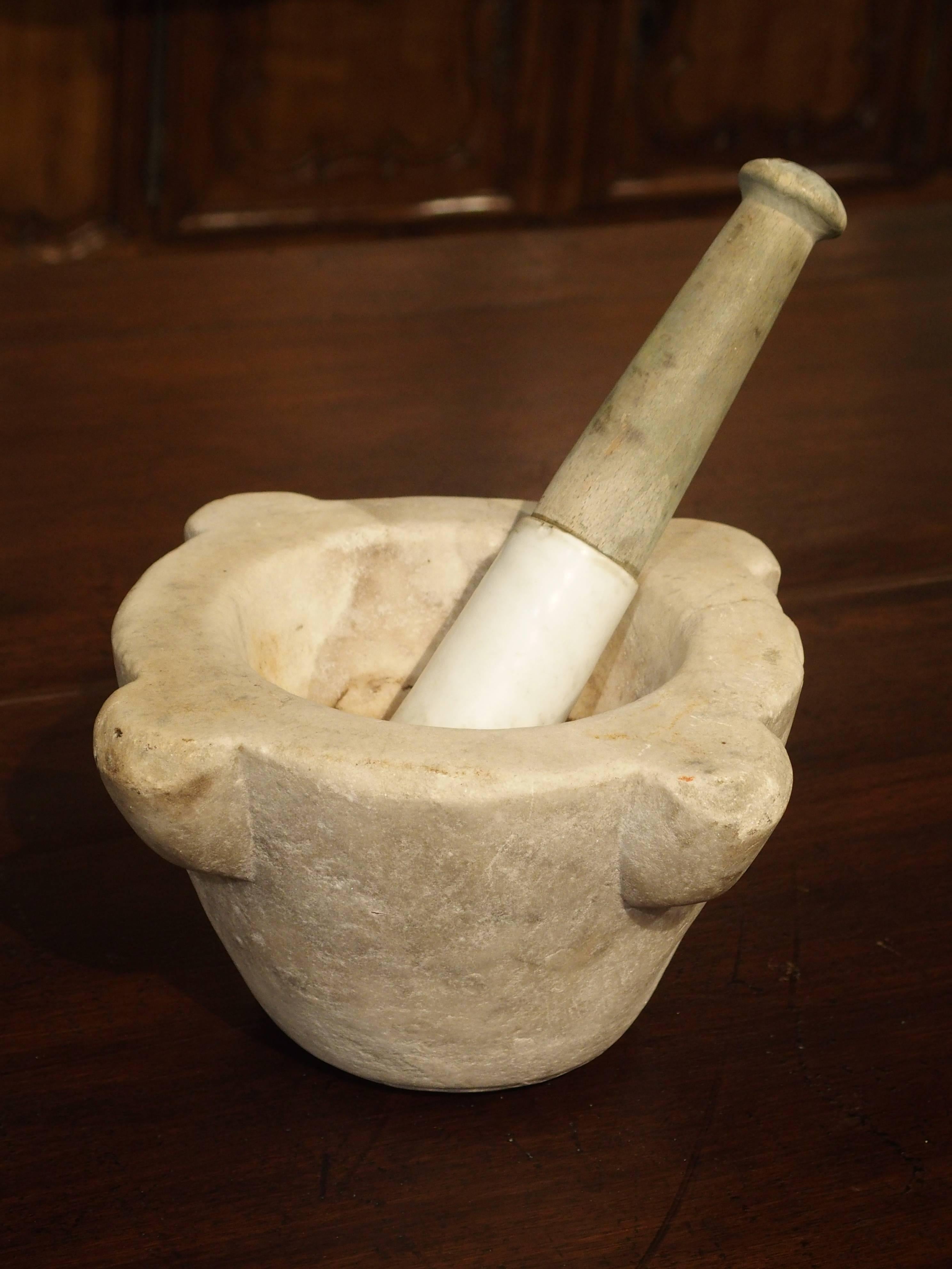 Bayeux

This small marble mortar and pestle with ceramic is from France and dates to the 19th Century. It is made from a cream colored marble with four outturned motifs. The pestle is made from wood and a rounded ceramic end piece marked Bayeaux.