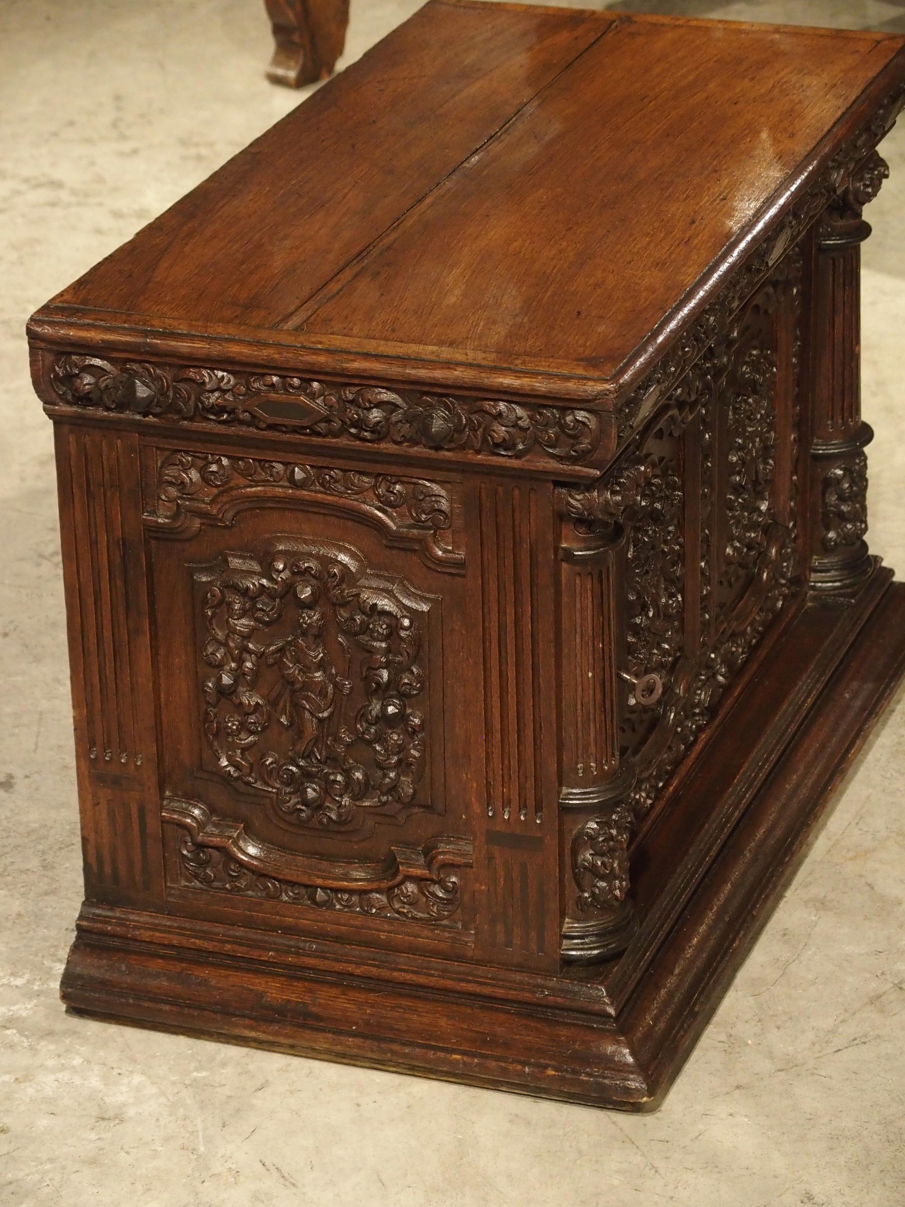 This antique oak rectangular cabinet has an abundance of finely carved motifs. At only 19 1/2 inches high, it is a good size for resting on a tabletop or pedestal. There is a plain top over carved panels on both sides and the front. The interior of