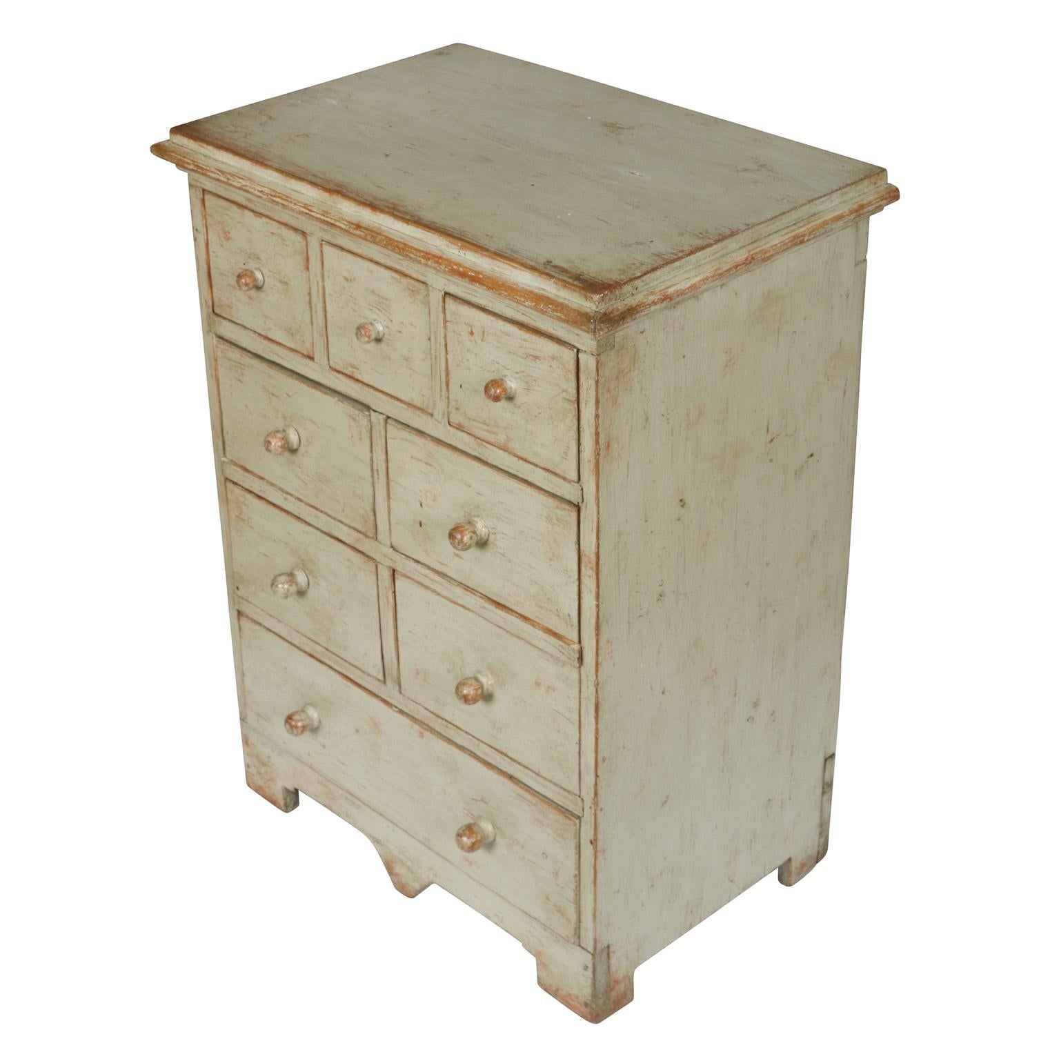 A sweet little painted chest with eight drawers in different sizes. The piece is painted in a soft gray blue and its size make it versatile--it can serve a purpose in any room or office.