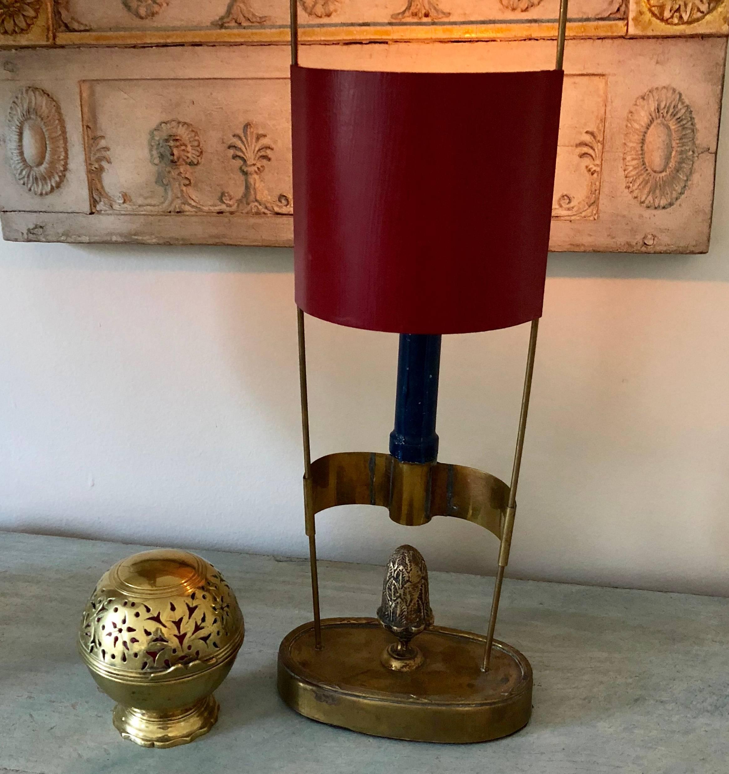 Small oval brass candlestick with a red painted shade and acorn centerpiece, Sweden early 19th Century.

