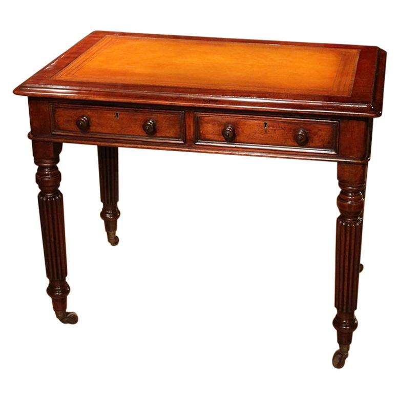 Beautiful small Victorian mahogany writing table with 2 drawers and light tan color leather top. Table is on porcelain wheels. Table is made as a freestanding model. Can therefore stand freely in the room. Perfect condition and a good quality