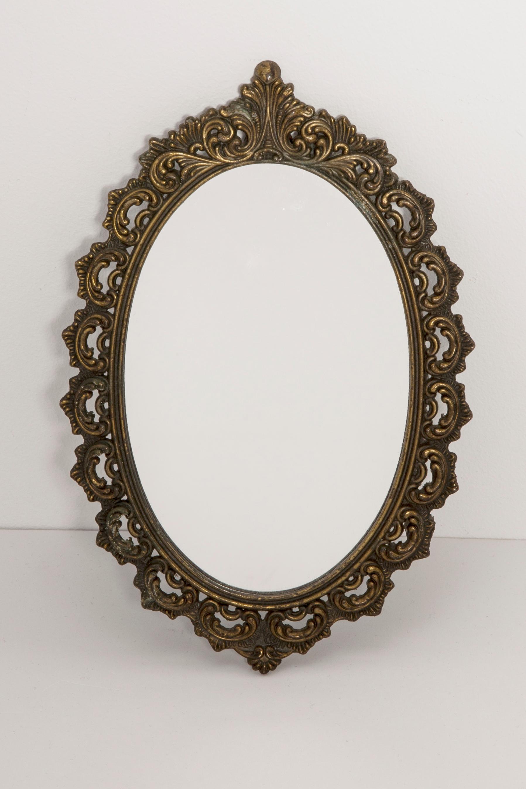 A beautiful mini oval mirror in a dark golden decorative frame from Italy. The frame is made of metal. Mirror is in very good vintage condition, no damage or cracks in the frame. Original glass. Beautiful piece for every interior! Signed 