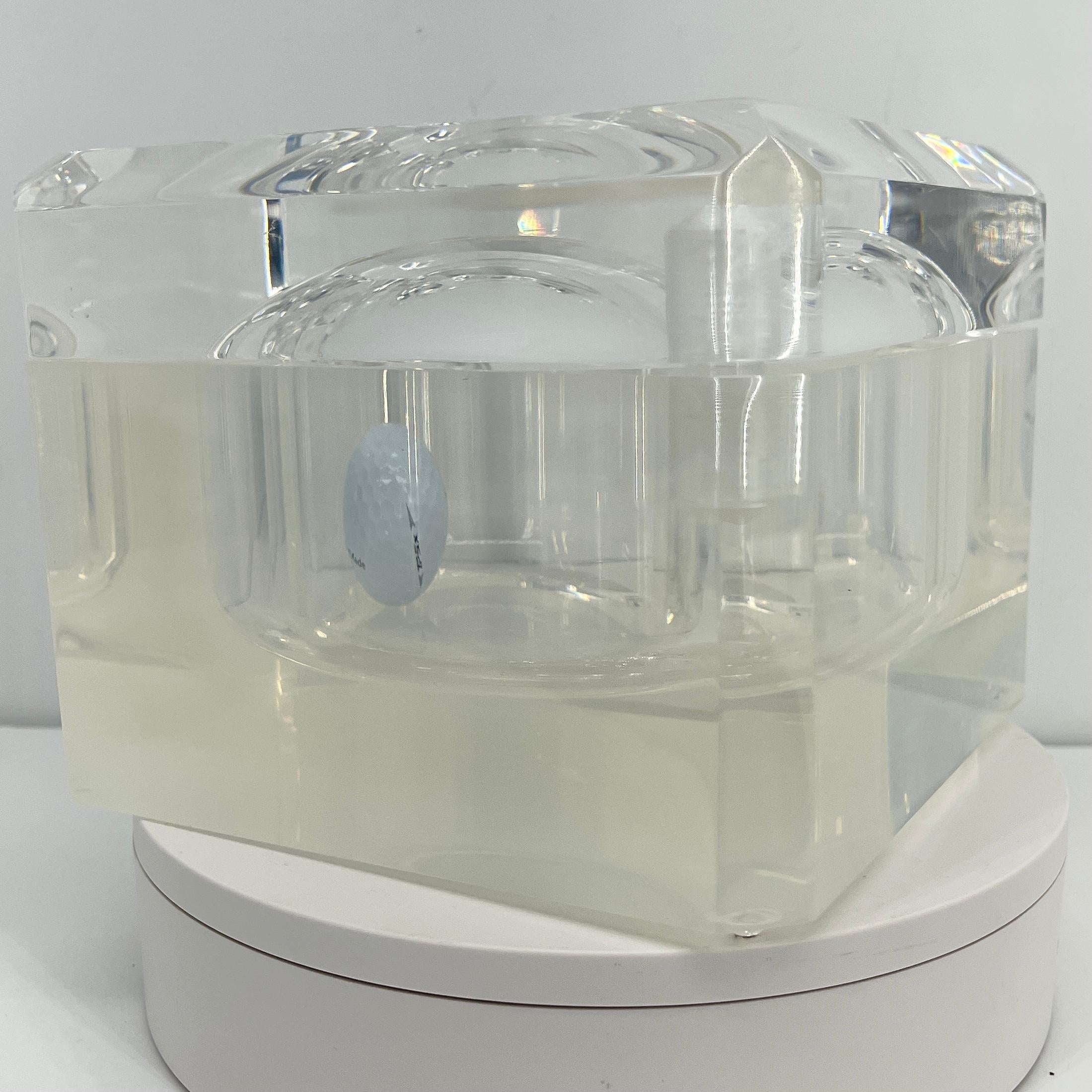 Mid-Century Modern lucite ice bucket. The polished lucite ice bucket will glow in the light of day as well as candlelit evenings. With beveled edges on the swivel top, this low profile bucket is a necessary addition to any modern decor. The interior