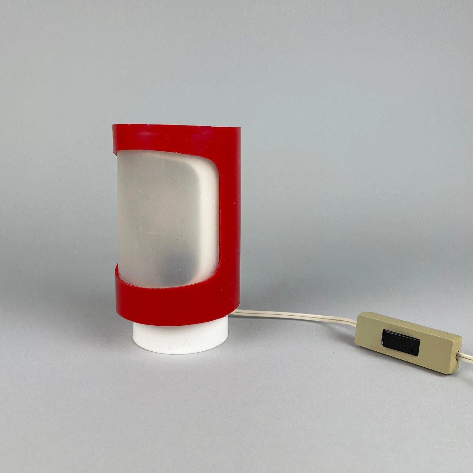 Vintage table lamp made of plastic. The red part can be rotated to regulate the strength of the light.