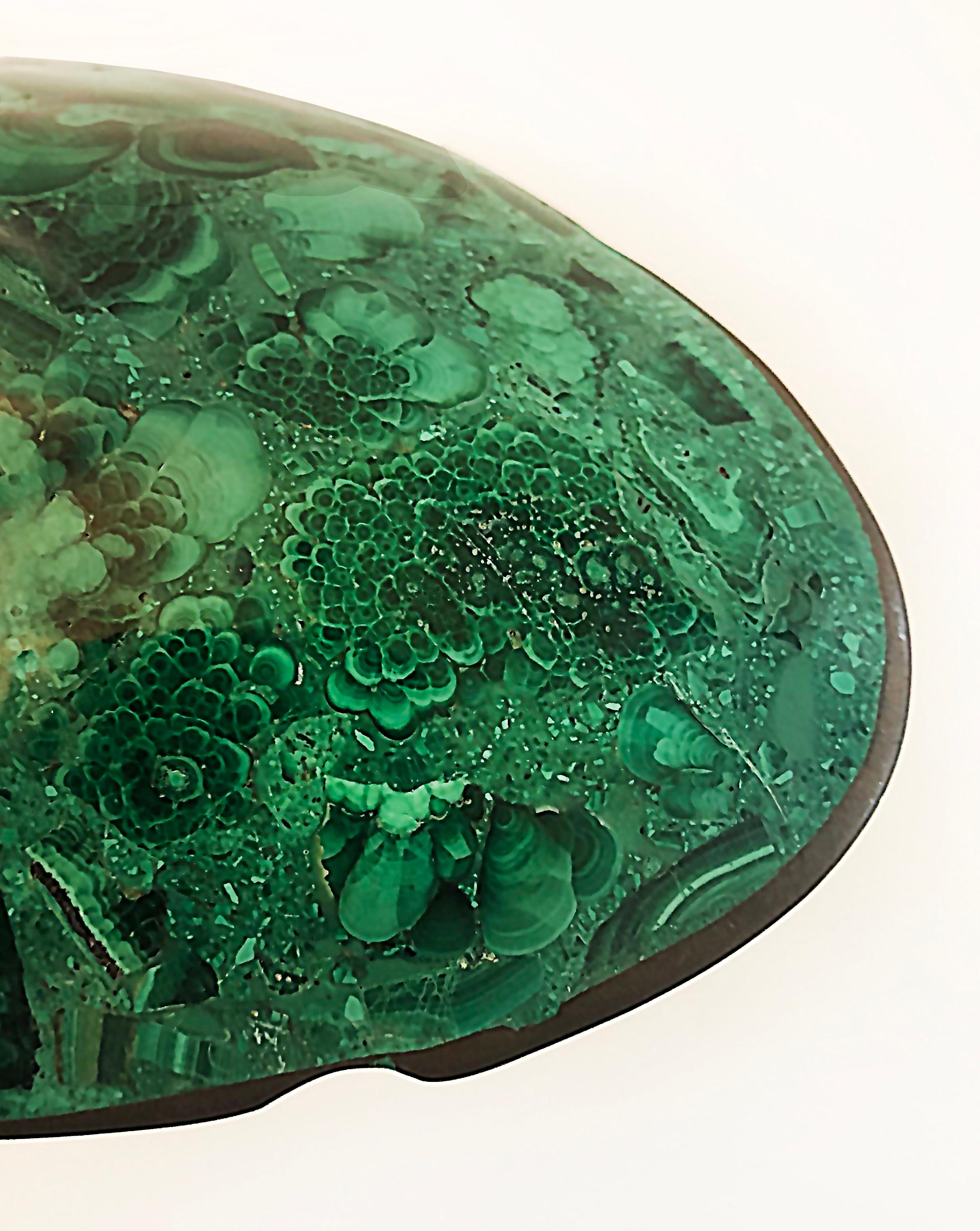 Small African Malachite carved stone oval tray catchall

Offered for sale is a small Modern 20th-century African malachite carved stone oval tray that is embellished with a thin brass rim. The piece is made in Zaire (Congo). It retains the original