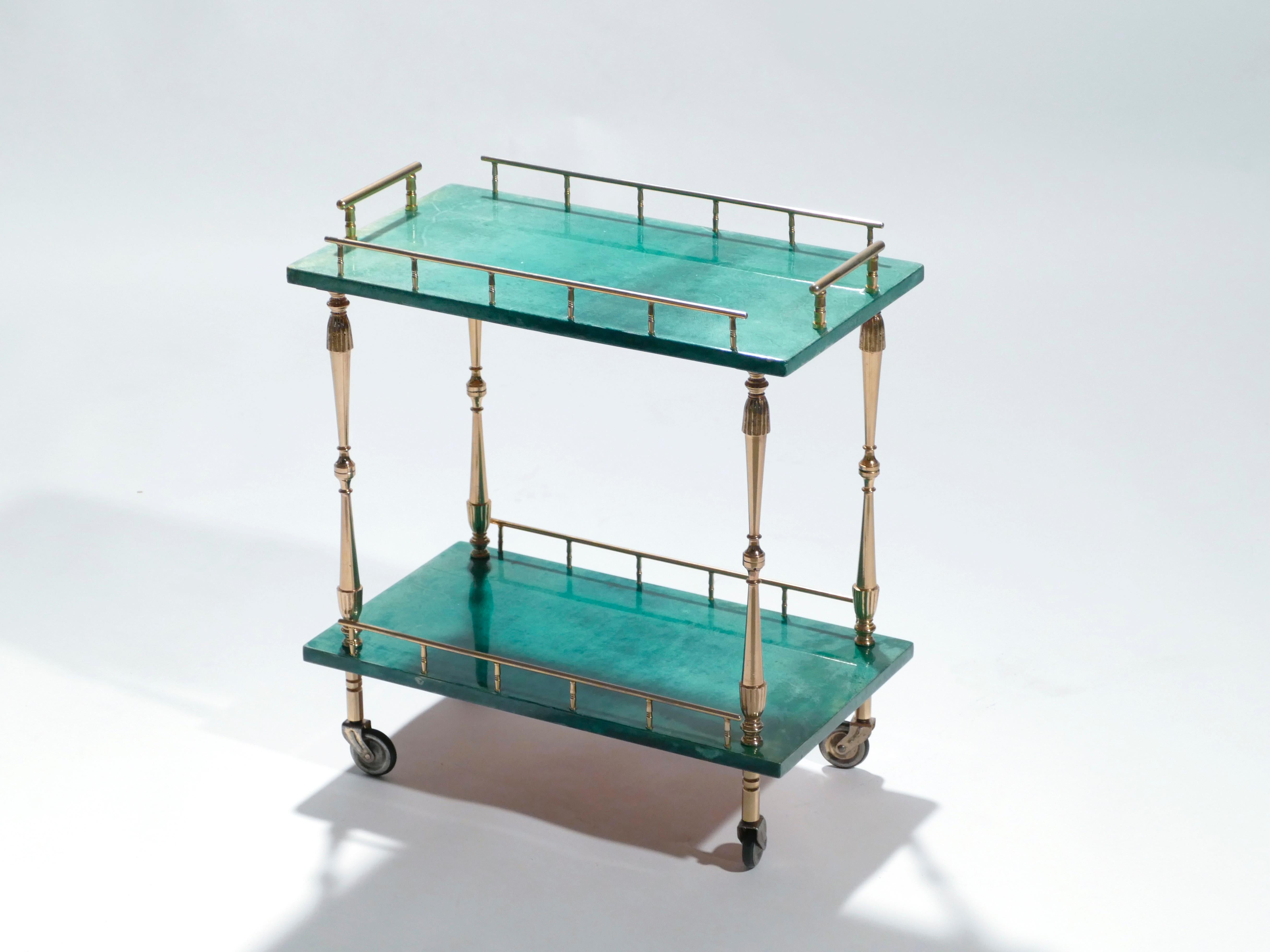 Aldo Tura designs nearly always incorporated goatskin parchment, often colored as seen here, in a deep emerald green. This small and highly decorative bar cart, then, seems to be the epitome of a Tura design. The varnished goatskin parchment