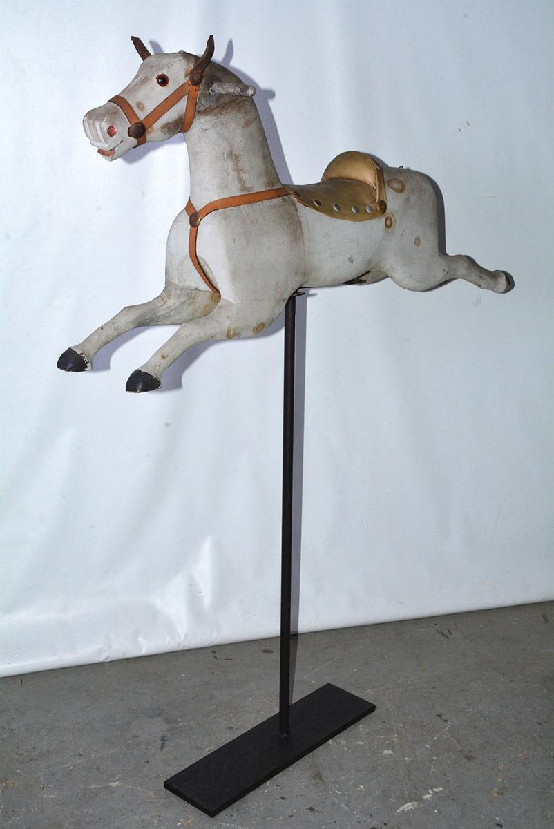 Wonderfully charming American painted wood horse is hand carved and was once a part of a part of a children's carousel that was often found in front of a store to amuse children while their parents are shopping. Now displayed on an iron stand making