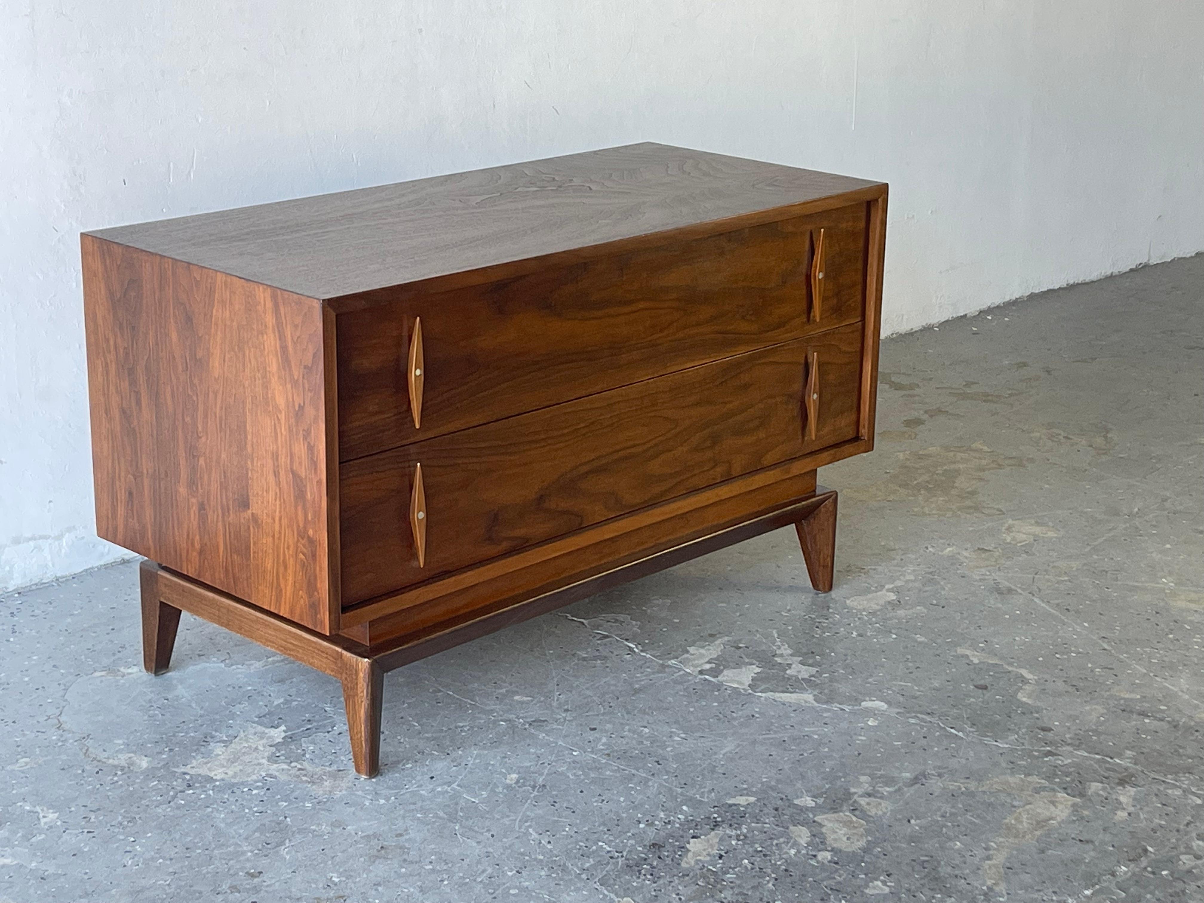 Uber cool Mid-Century Modern small credenza / Media stand by American of Martinsville. This piece has two spacious drawers with wonderful elongated diamond pulls. The walnut wood grain is exquisite from every angle. 

42 in wide 19 in deep 24.75