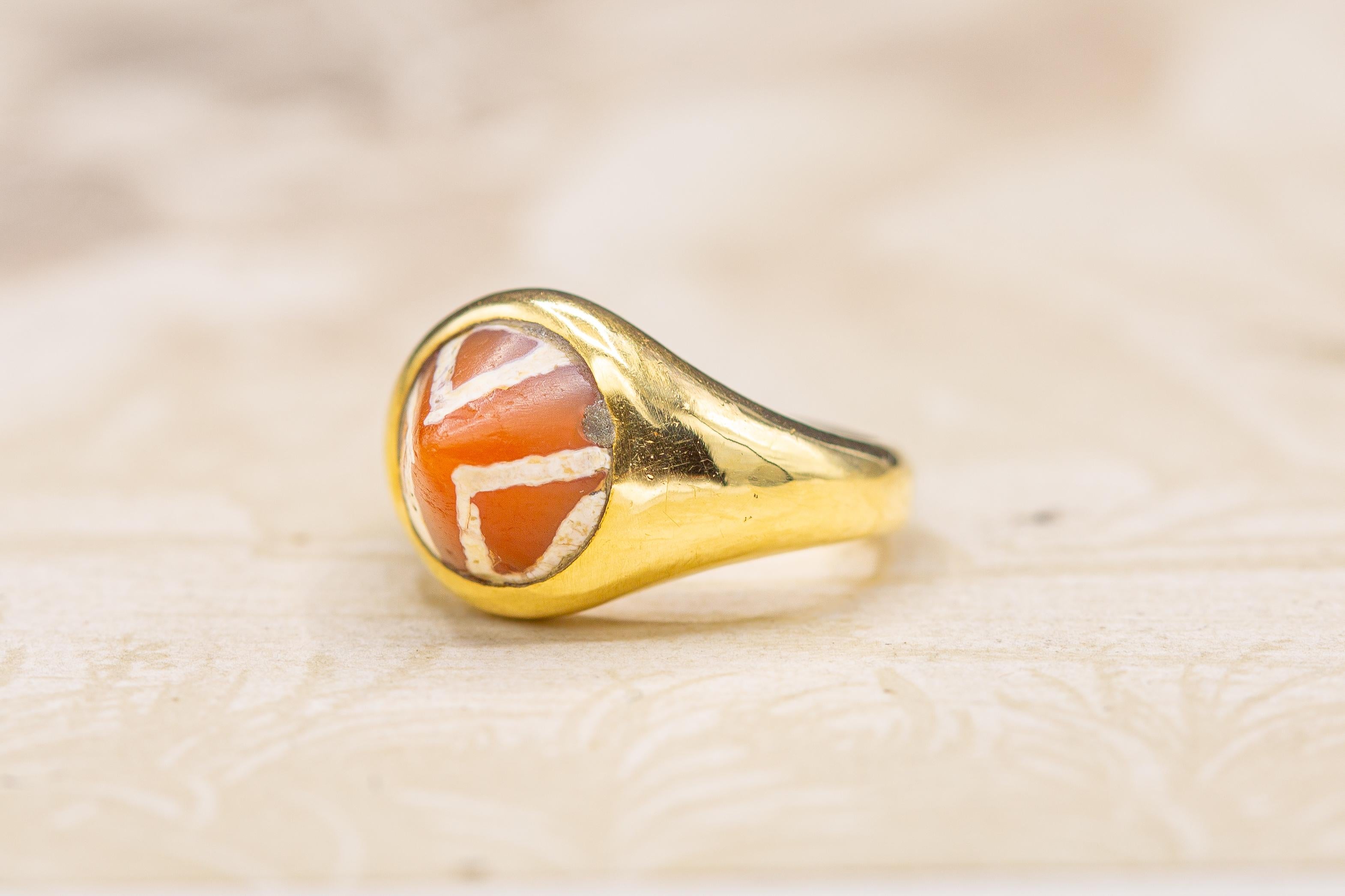 A superb and rare ancient Indus Valley etched carnelian bead ring. The conical shaped carnelian gemstone in the centre dates from the middle of the third millennium BC. Deep orange in colour with white patterned etchings, these beads originate from
